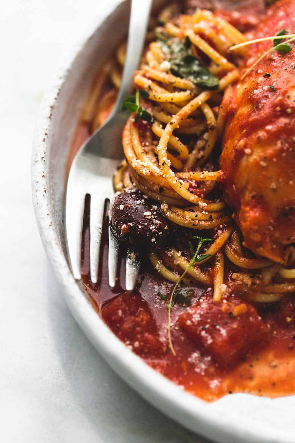 close up of slow cooker chicken cacciatore and a fork on a plate.