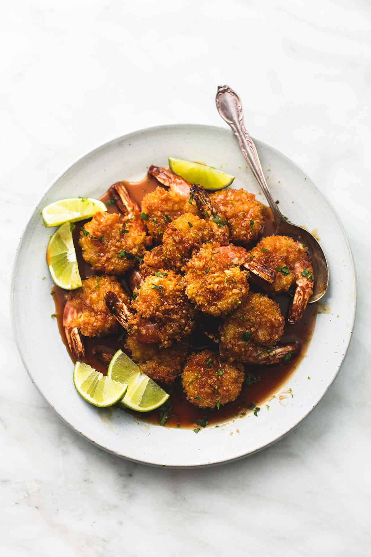 top view of baked crispy honey lime shrimp with a spoon on a plate.