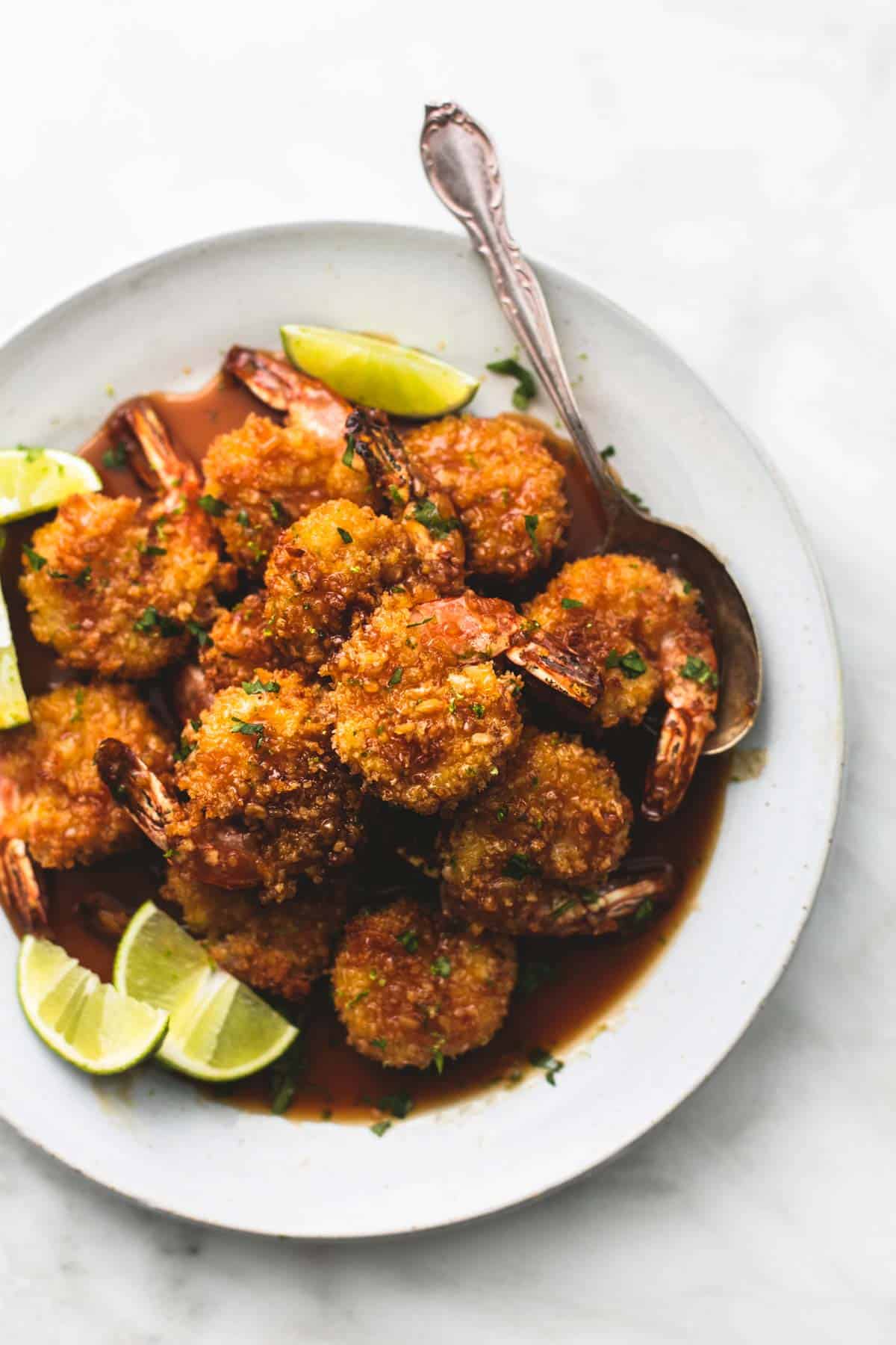 top view of baked crispy honey lime shrimp with a spoon on a plate.