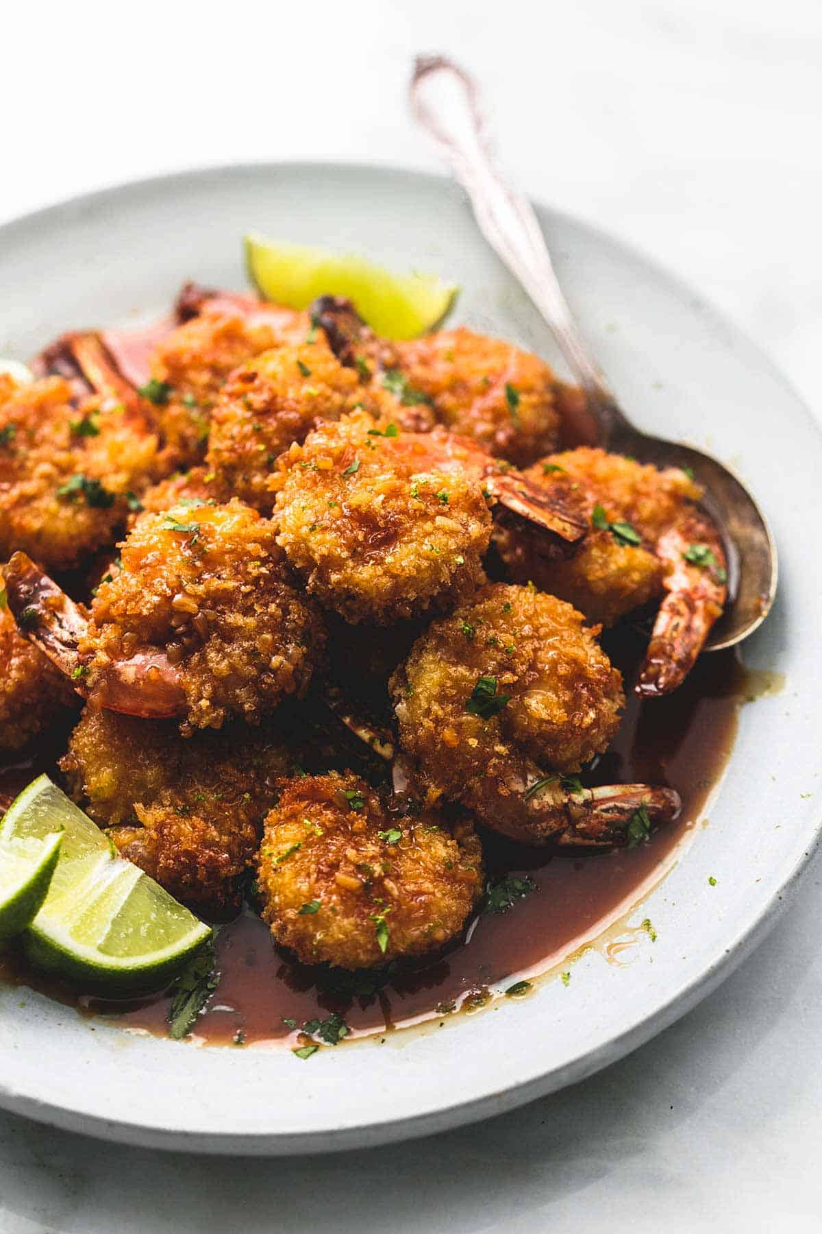 baked crispy honey lime shrimp with a spoon on a plate.