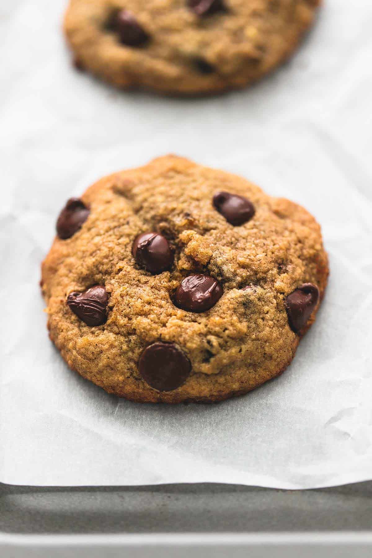 a banana chocolate chip cookie with another cookie in the background.