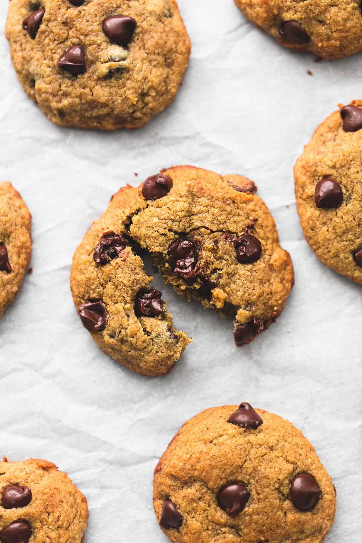 a banana chocolate chip cookie split in half surrounded by more cookies.