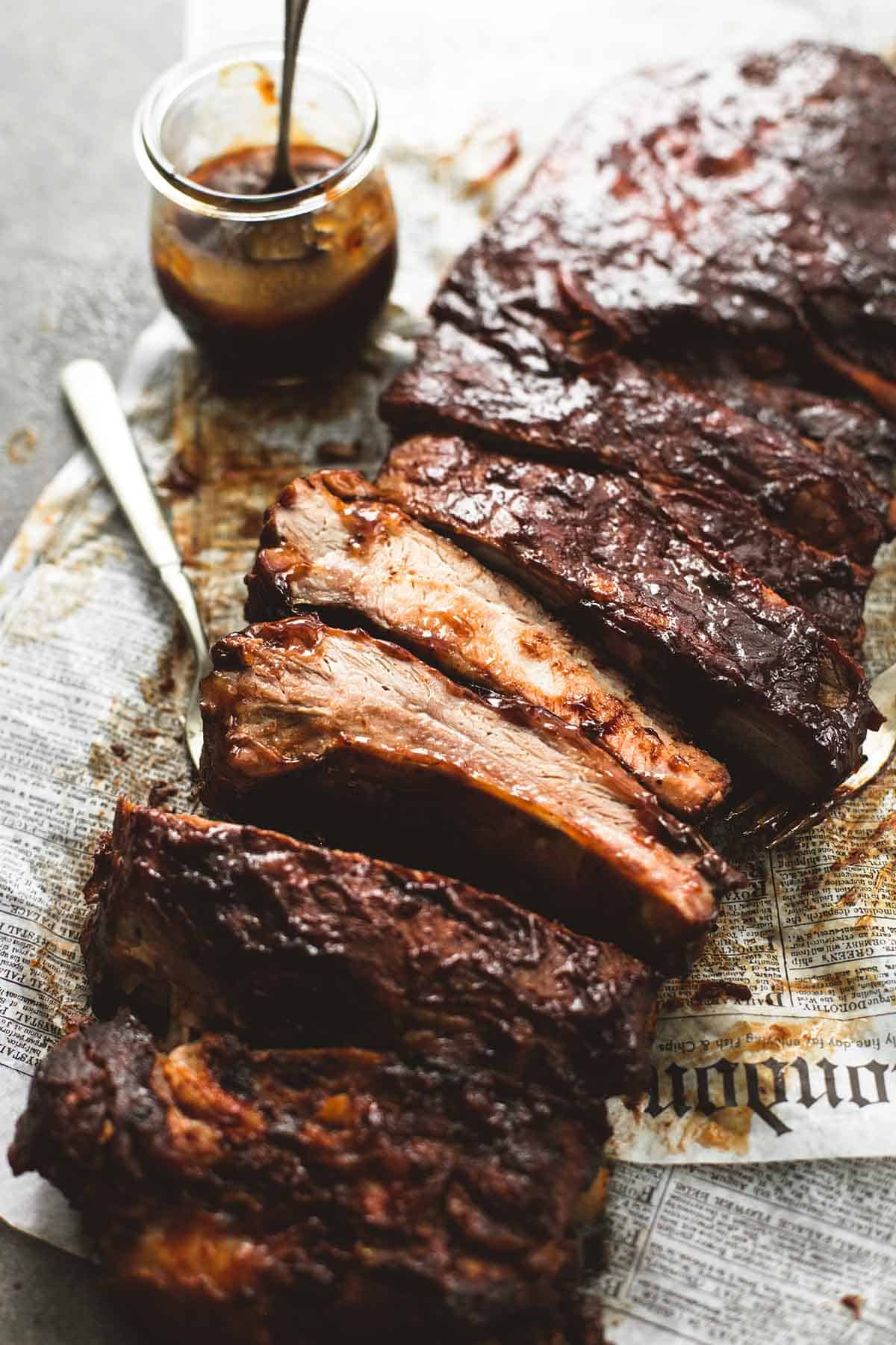 slow cooker bbq ribs with a fork and a jar of sauce on the side.
