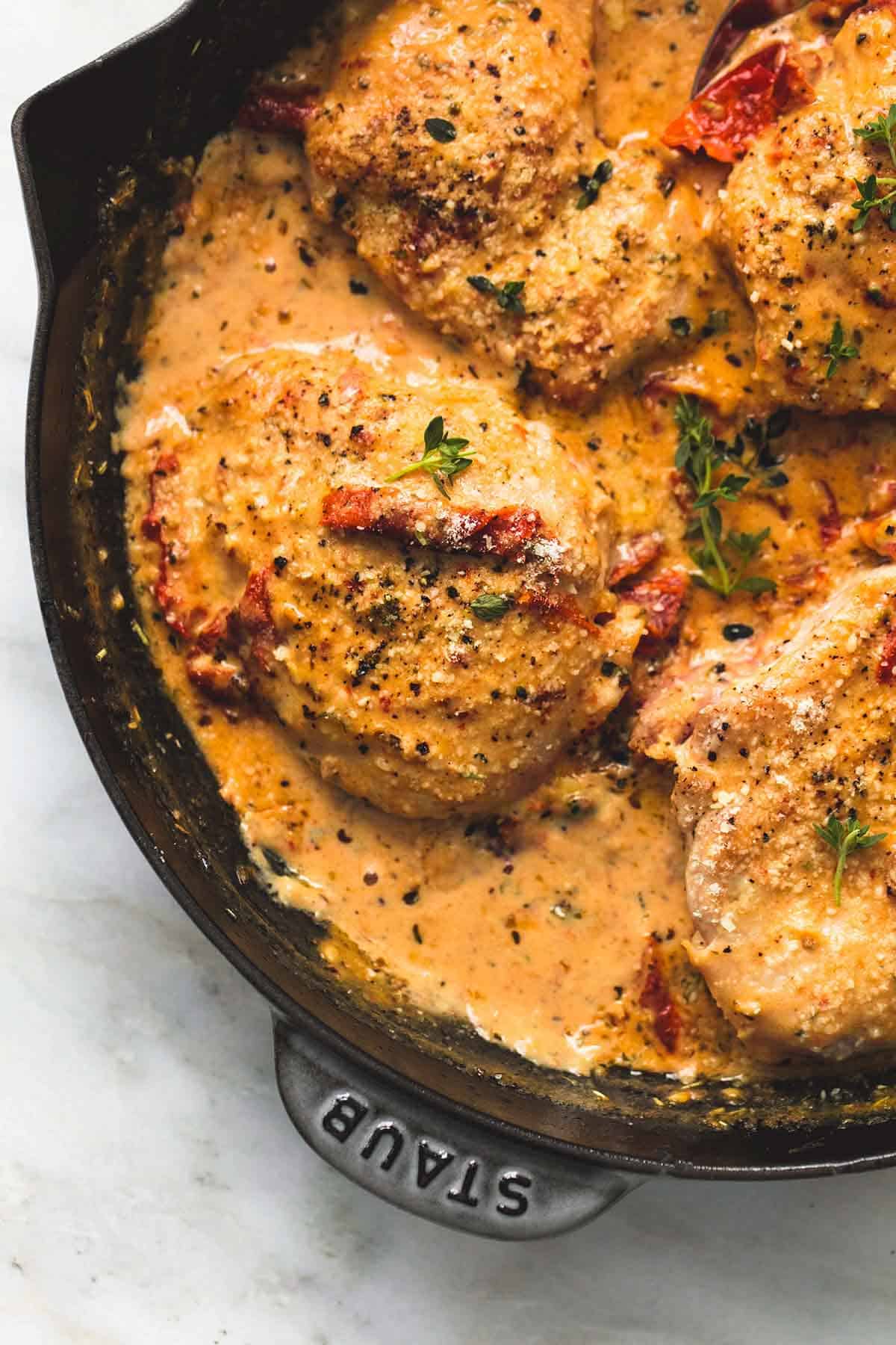 close up top view of chicken in sun dried tomato cream sauce in a skillet.