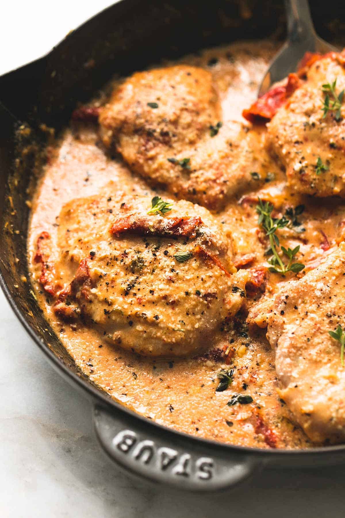 close up of chicken in sun dried tomato cream sauce in a skillet.