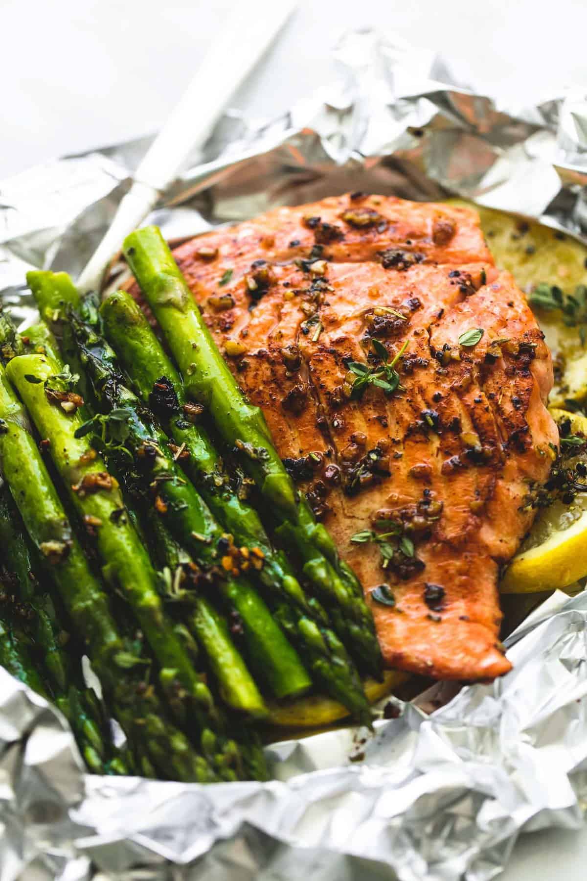 up close view of salmon and asparagus with lemon slices in an open foil packet