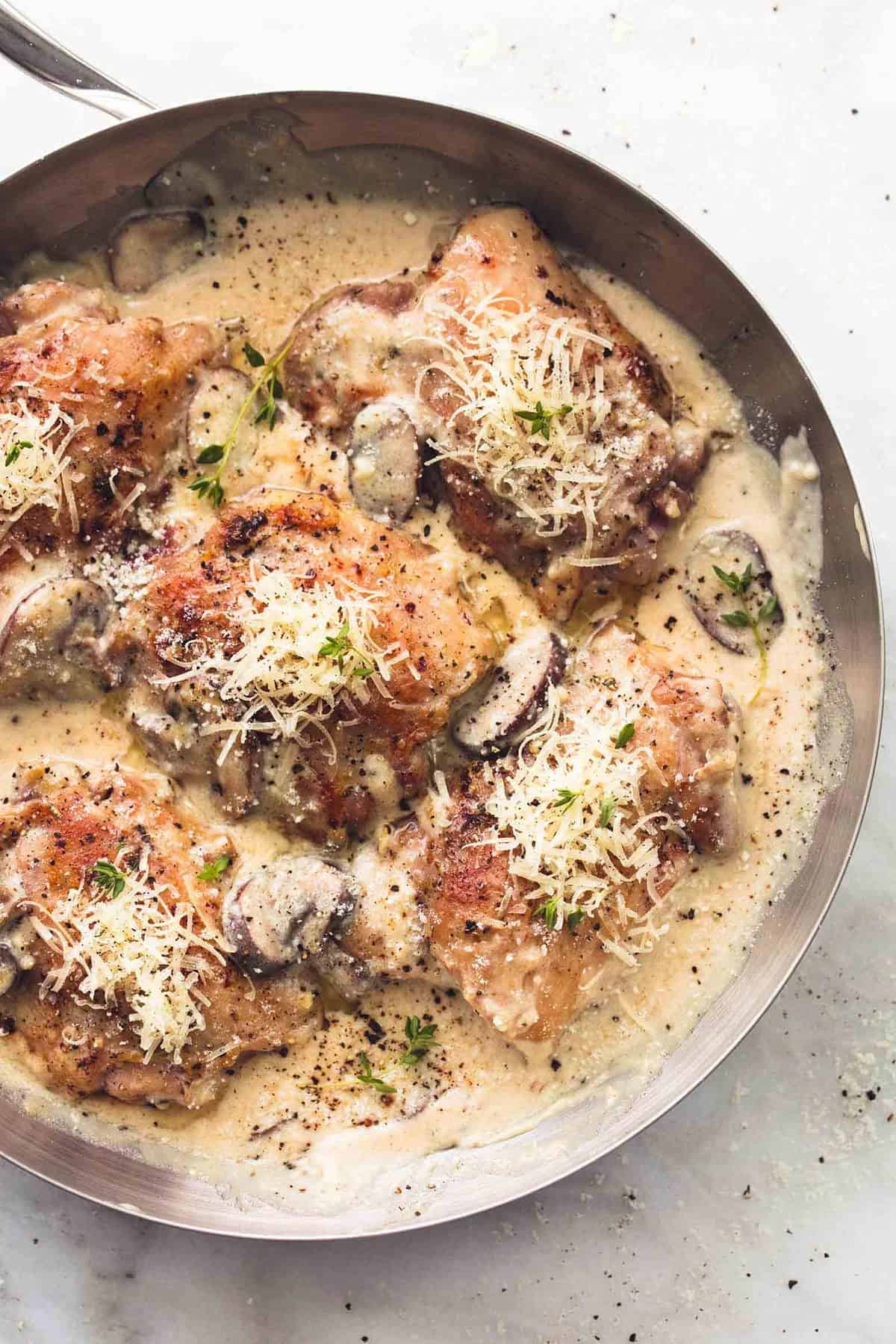 top view of creamy parmesan chicken and mushrooms in a pan.