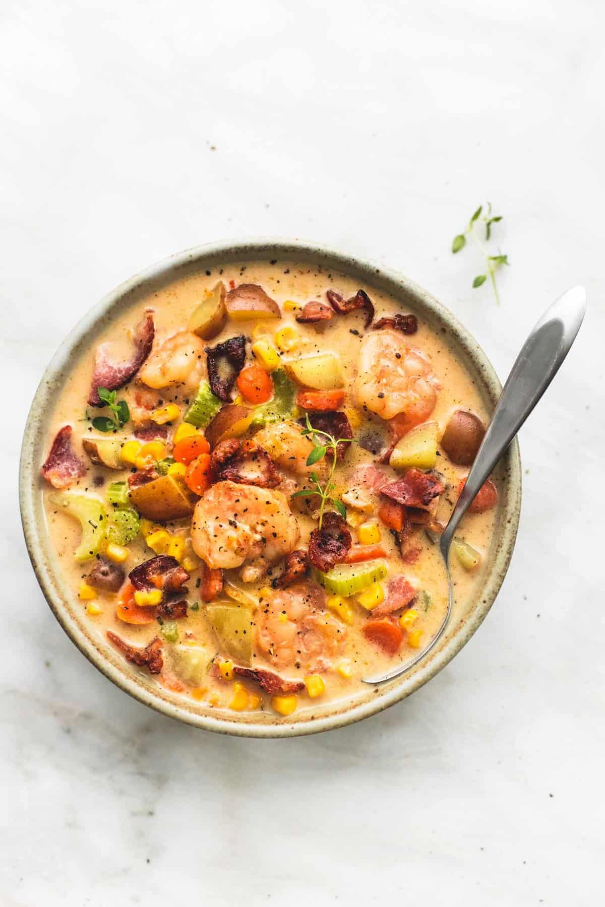 top view of shrimp and bacon corn chowder with a spoon in a bowl.