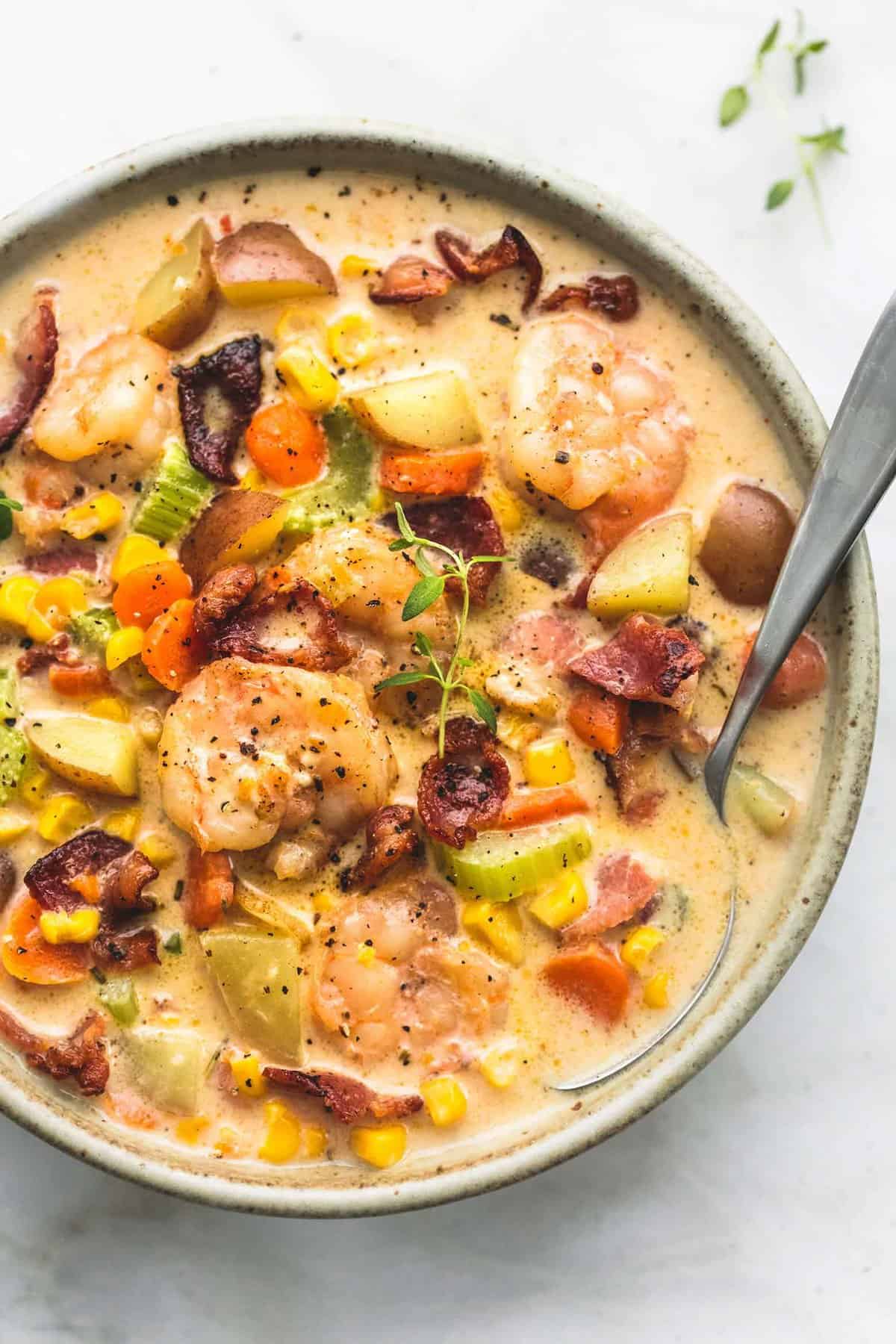 top view of shrimp and bacon corn chowder and a spoon in a bowl.