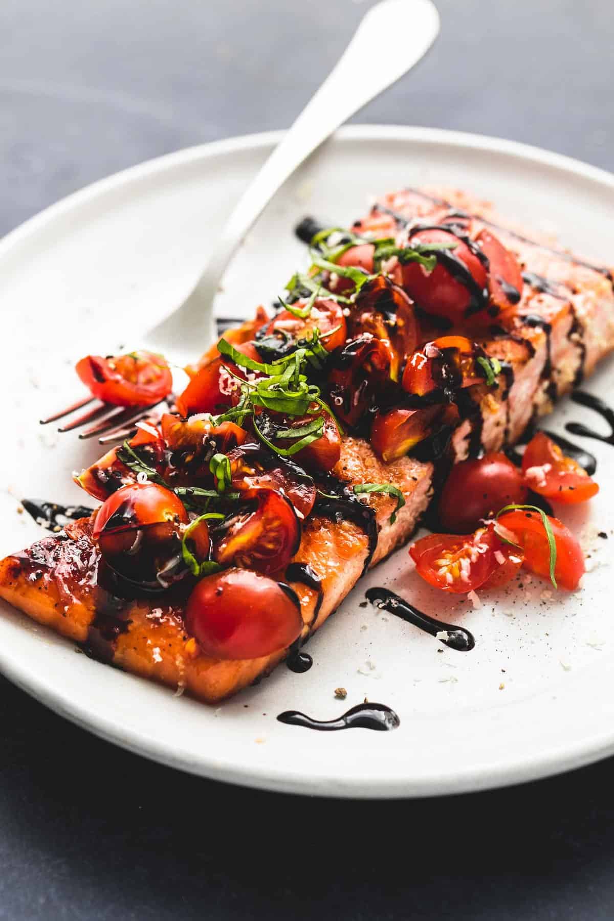 honey balsamic bruschetta salmon with a fork on a plate.