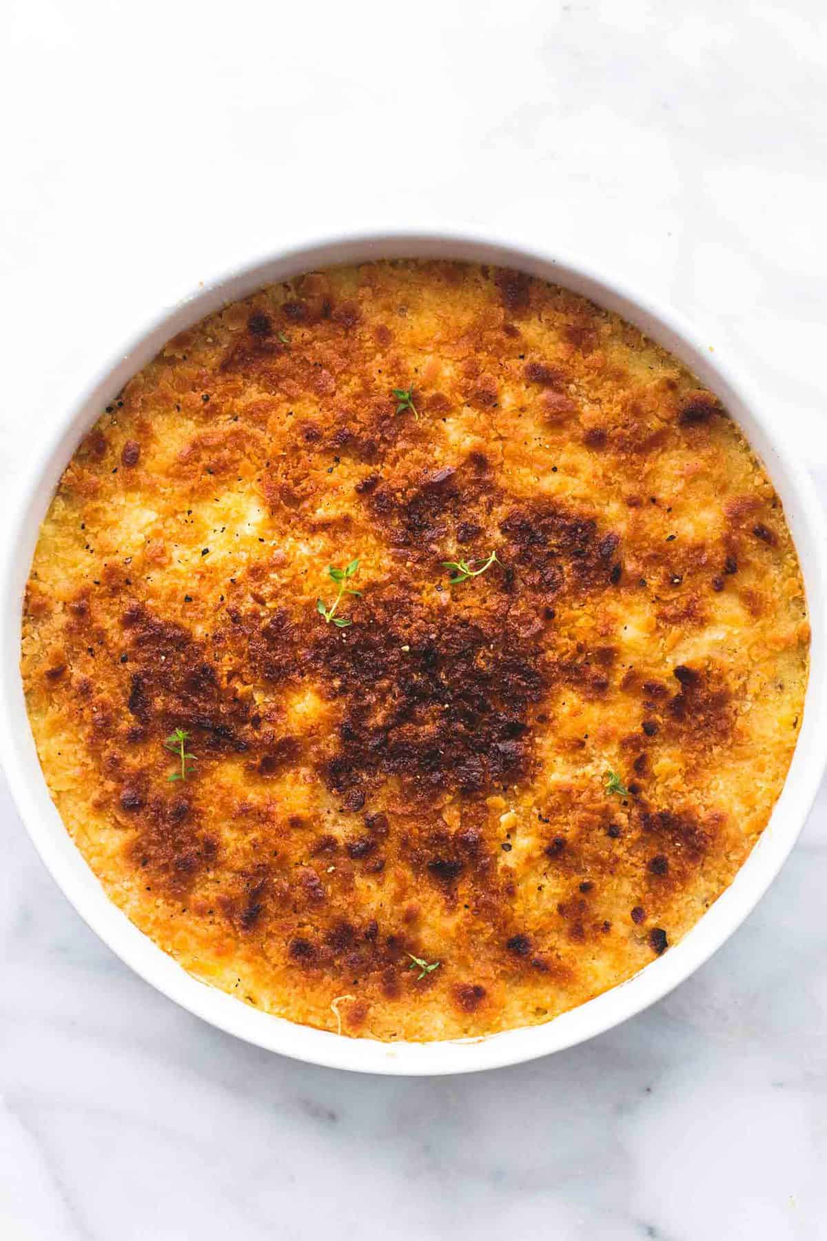 top view of baked parmesan creamed corn in a round serving tray.