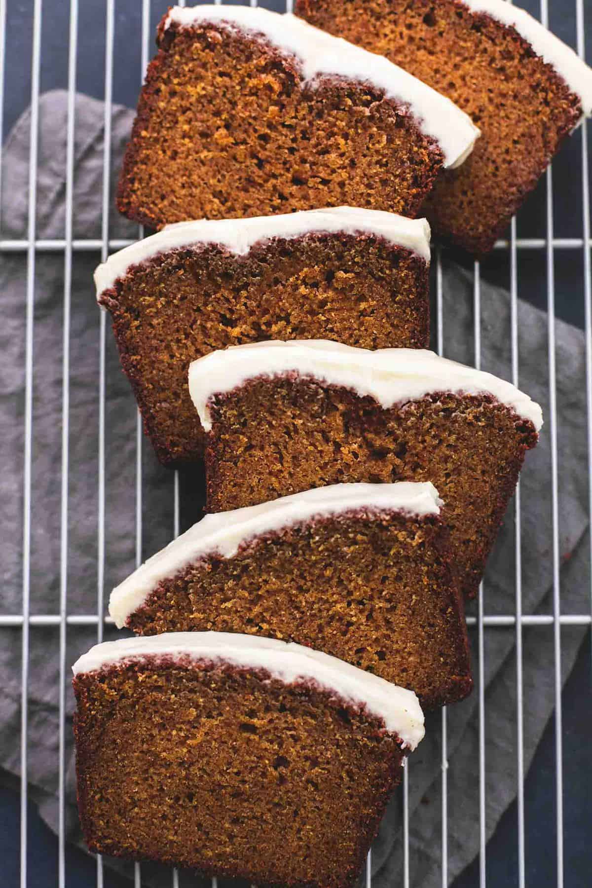 top view of slices of cream cheese frosted pumpkin bread on a cooling rack.