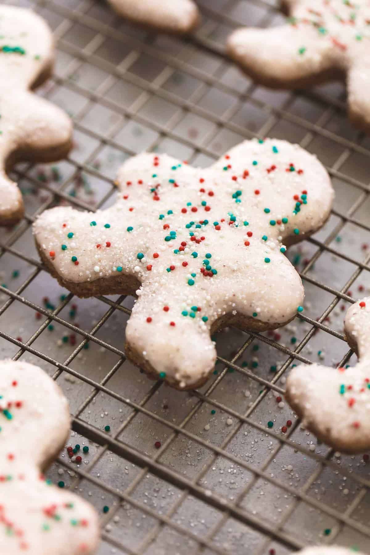 close up of a gingerbread sugar cookie with more cookies around it on a cooling rack.