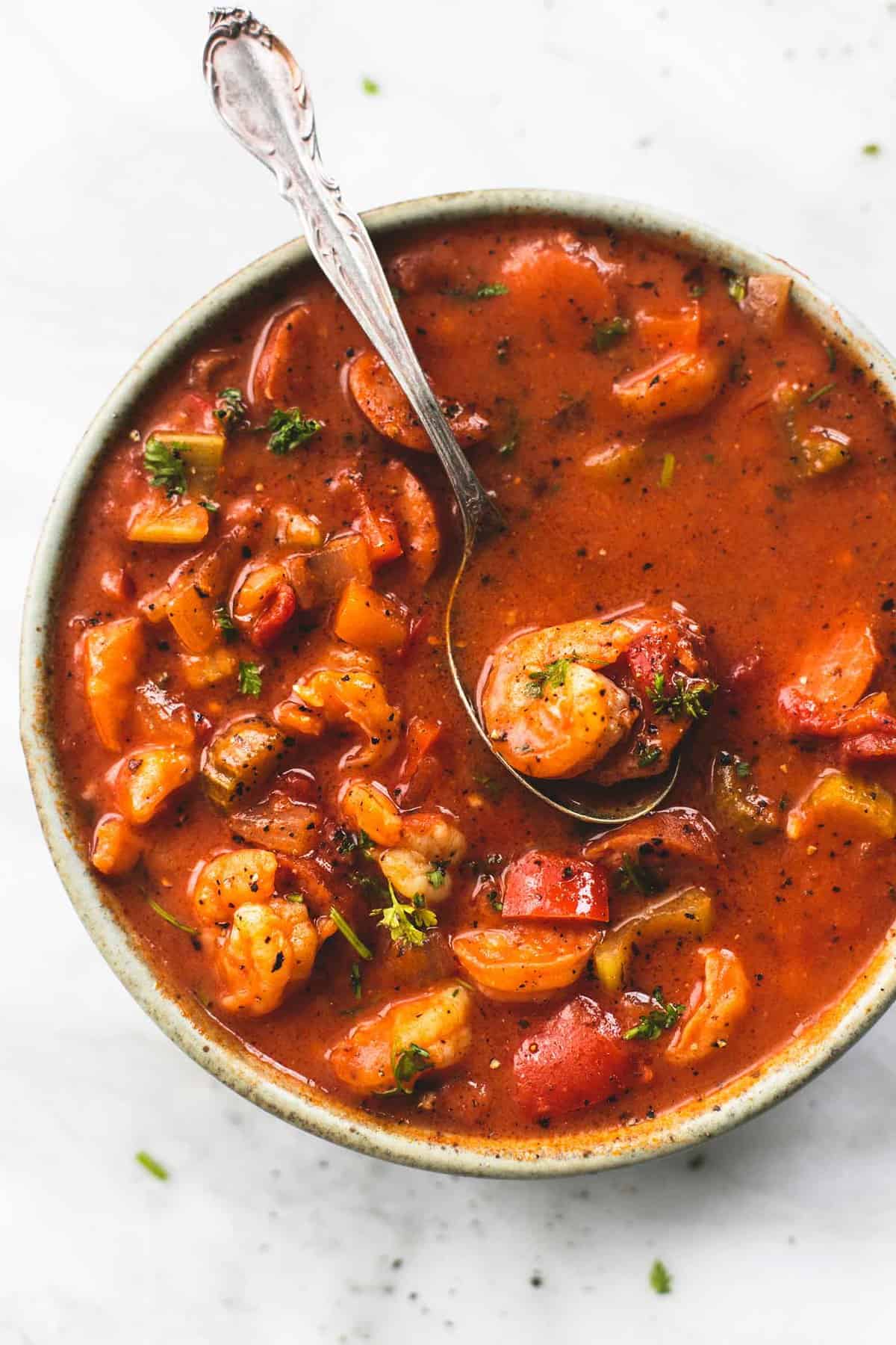 top view of shrimp and sausage gumbo with a spoon in a bowl.