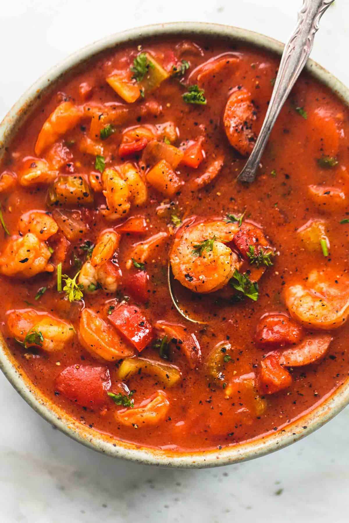 top view of shrimp and sausage gumbo with a spoon in a bowl.