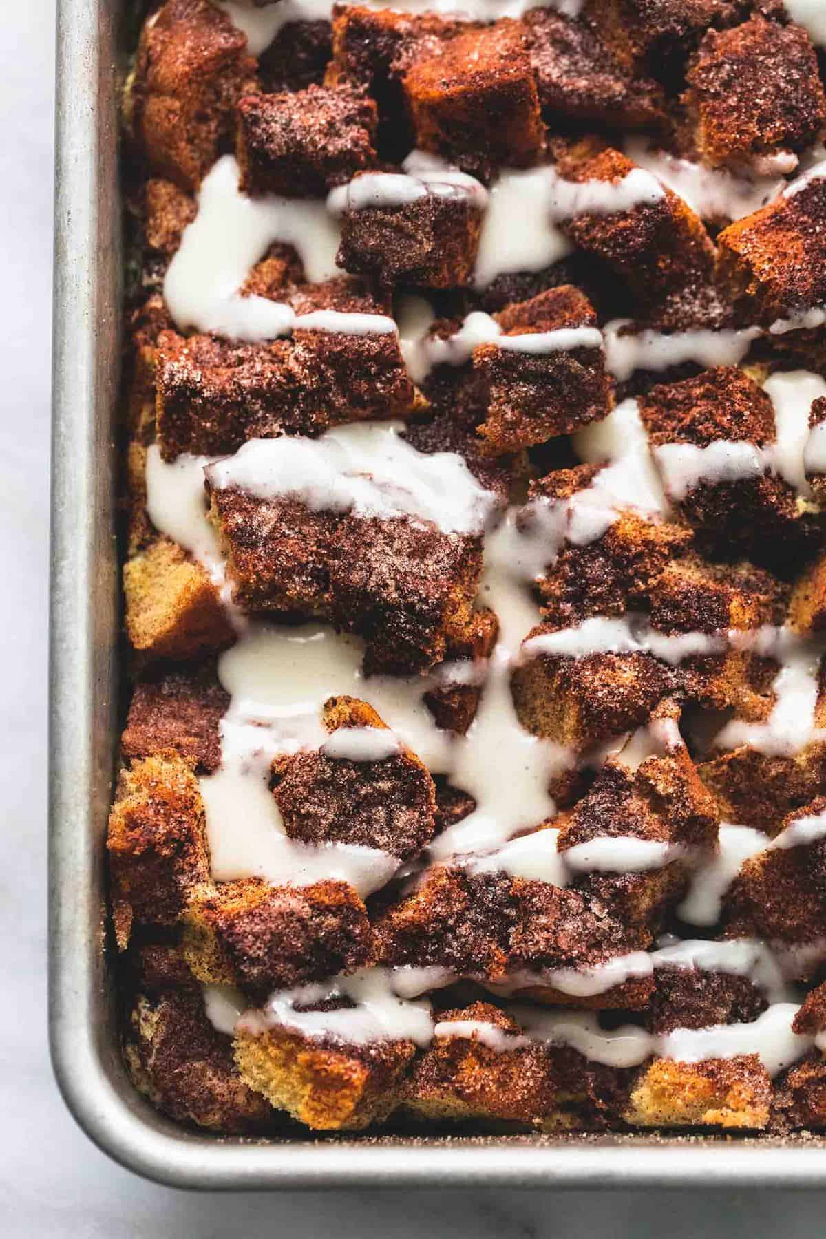 close up top view of overnight cinnamon roll French toast casserole in a baking sheet.