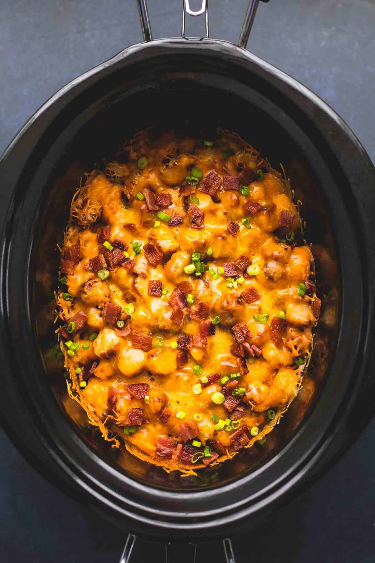 top view of slow cooker loaded tater tot breakfast casserole in a slow cooker.