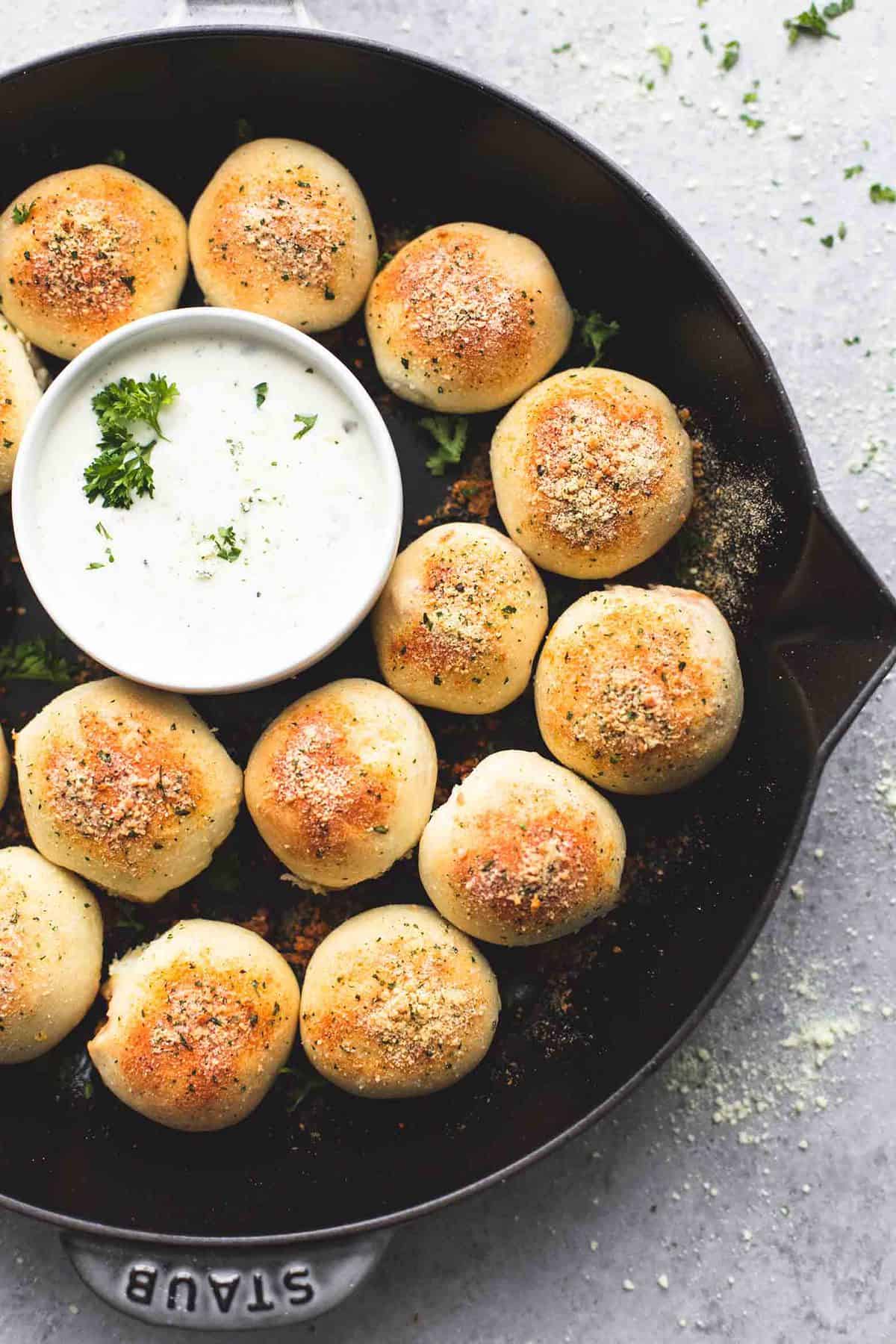 top view of bbq chicken bites around a sauce of dipping bowl all in a pan.