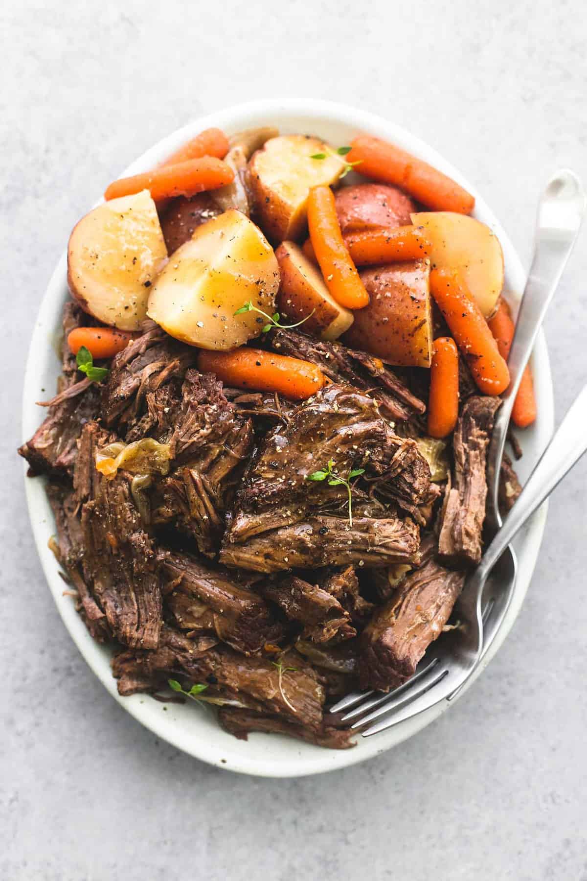 top view of instant pot pot roast and potatoes with a fork on a plate.
