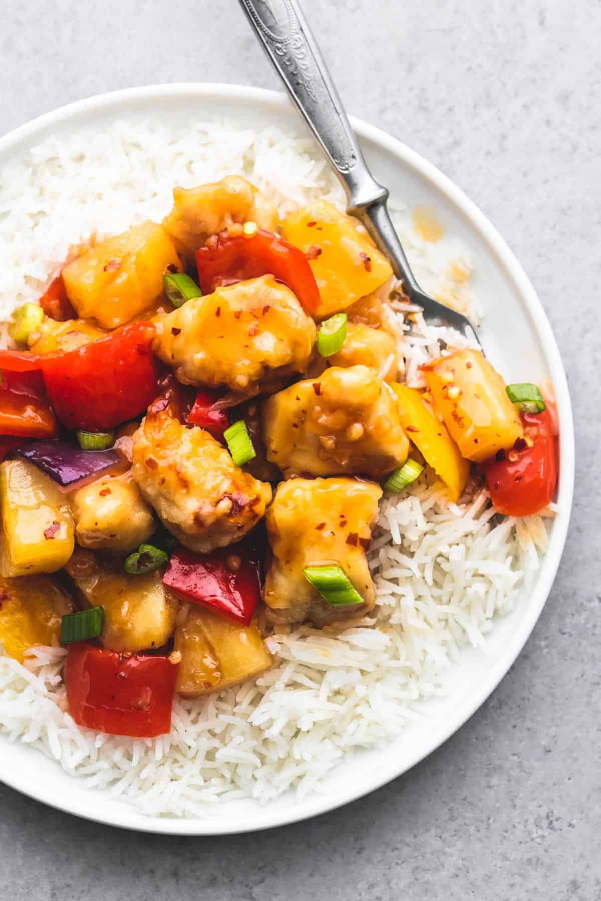 top view of sheet pan sweet fire chicken on rice with a fork on a plate.