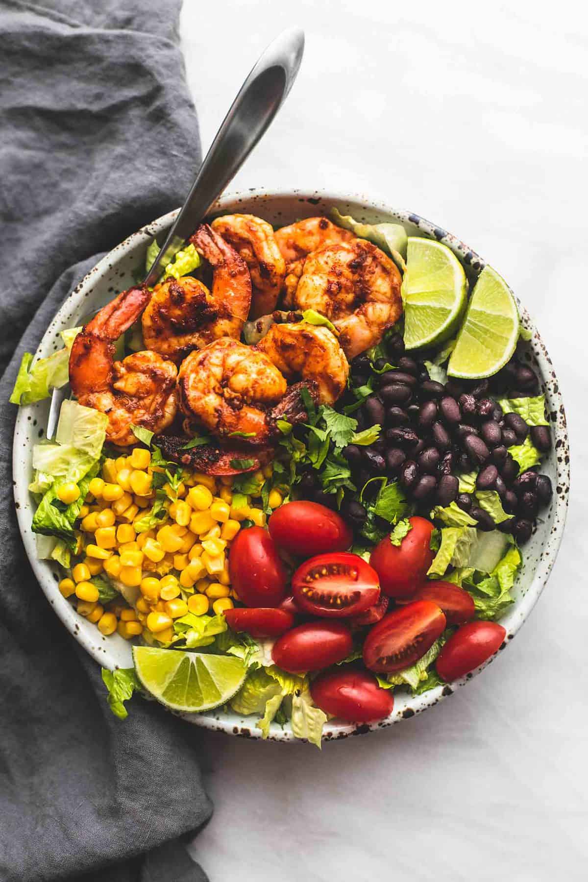 top view of fiesta lime shrimp salad with a fork on a plate.