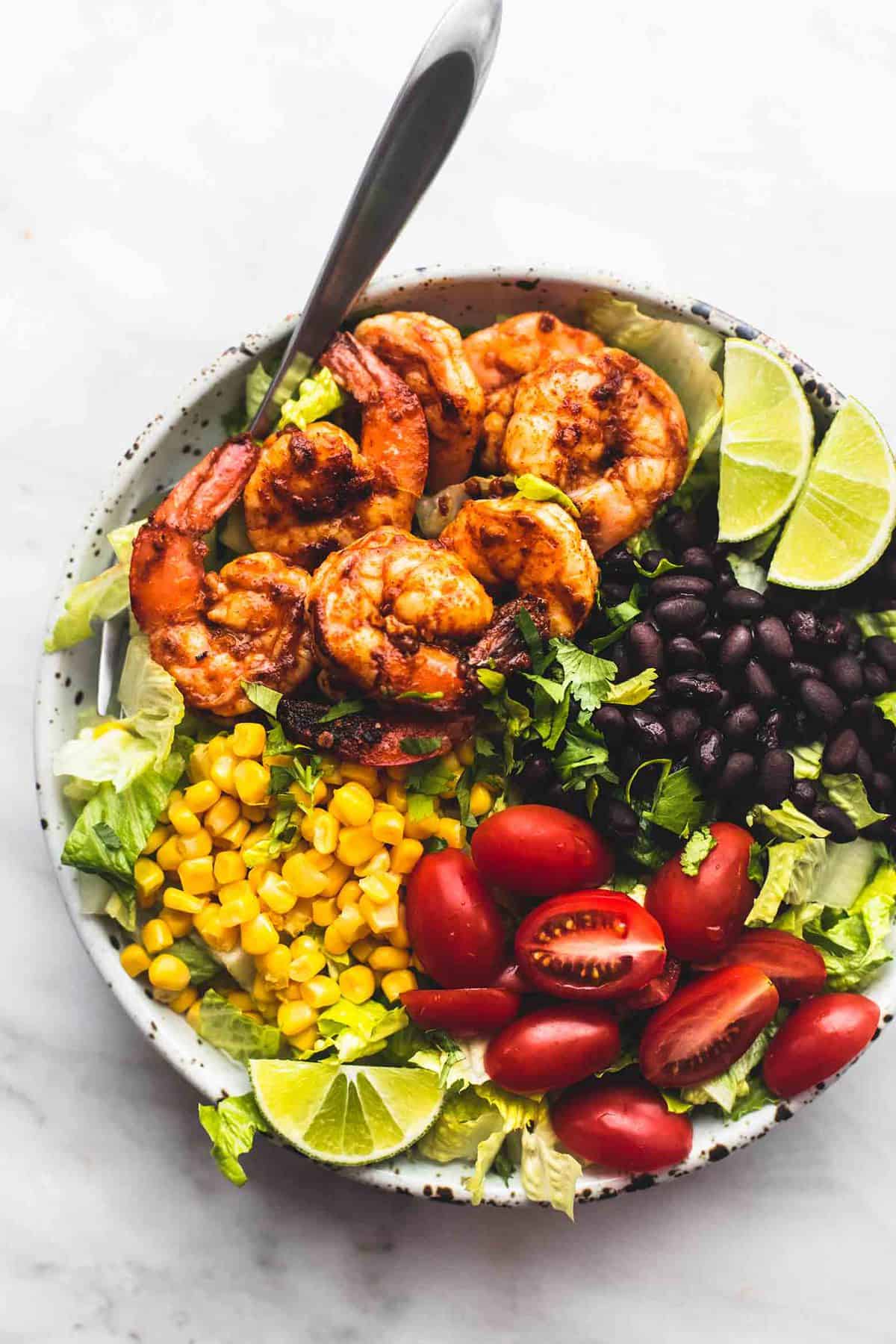 top view of fiesta lime shrimp salad with a fork on a plate.