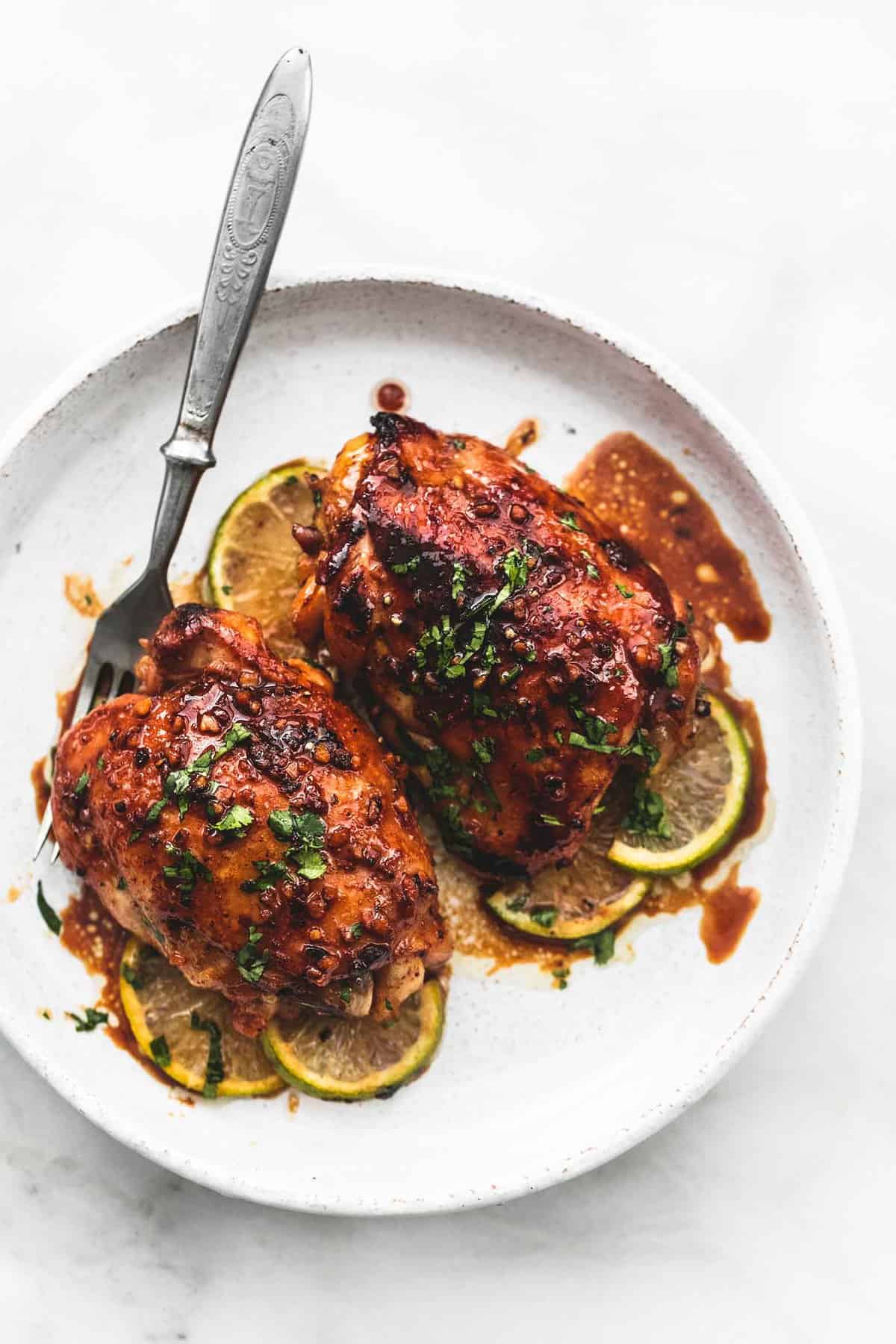 top view of honey lime garlic chicken with a fork on a plate.