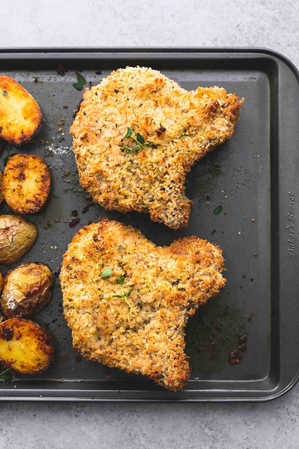 top view of shake and bake ranch pork chops with potatoes on a baking sheet.