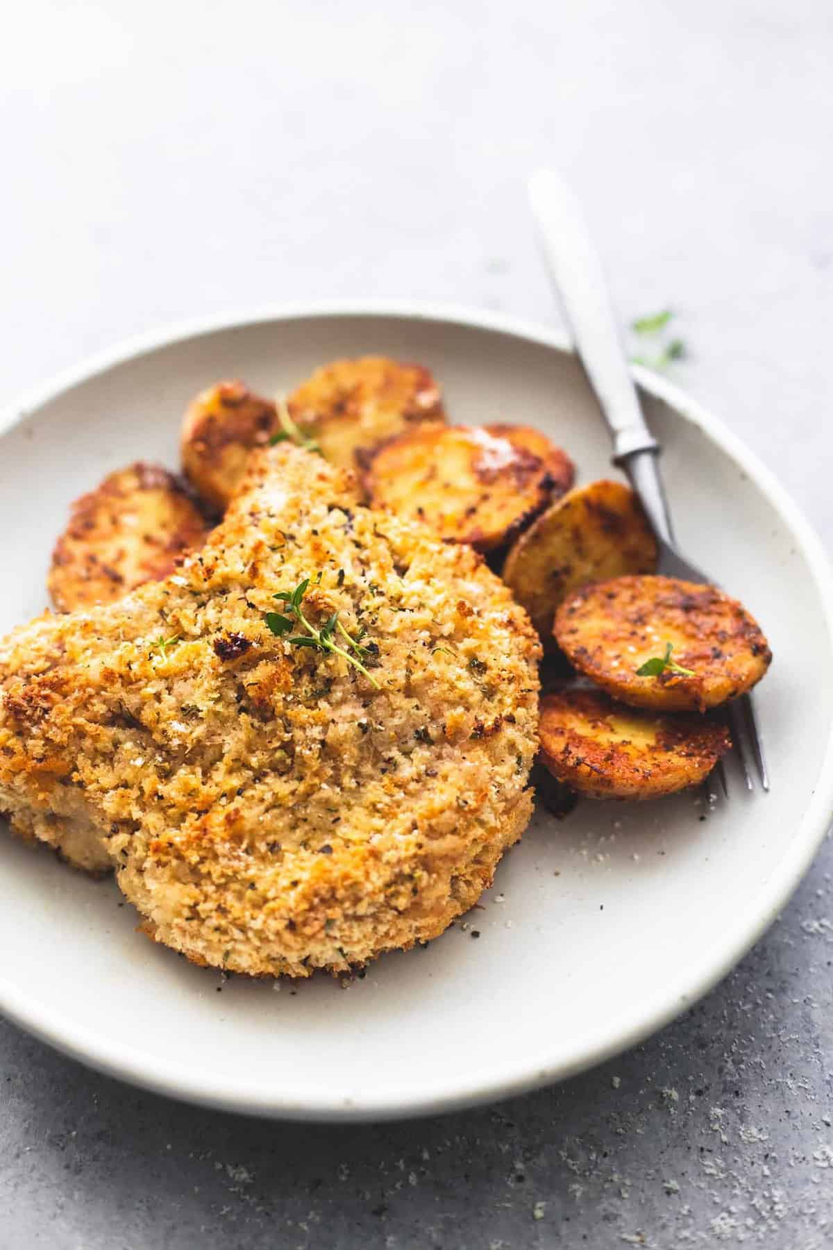 a shake and bake ranch pork chop with potatoes with a fork on a plate.