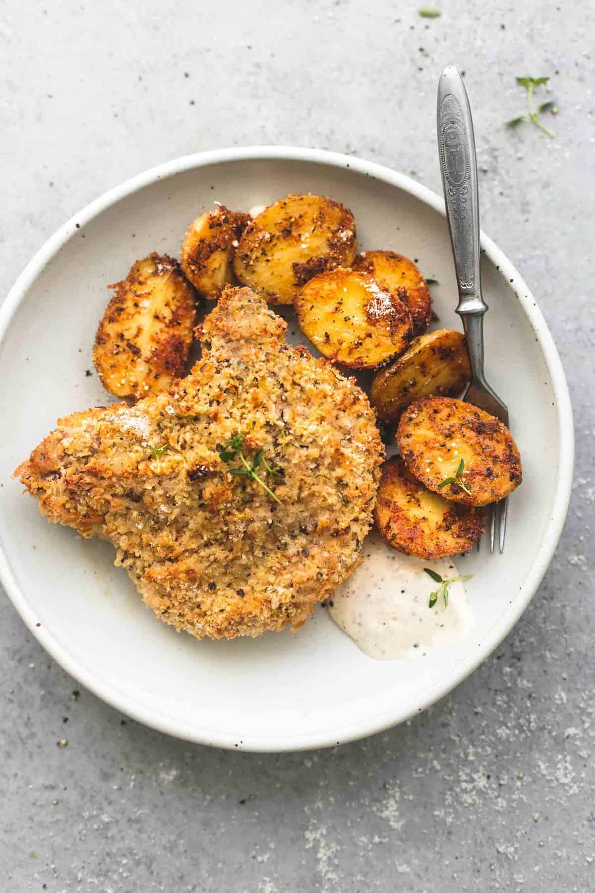 top view of shake and bake ranch pork chops with potatoes with a fork on a plate.