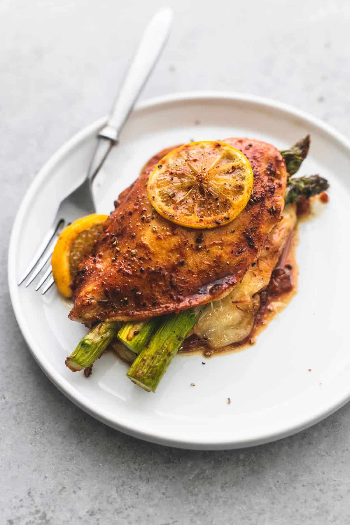 a piece of asparagus stuffed chicken with a fork on a plate.