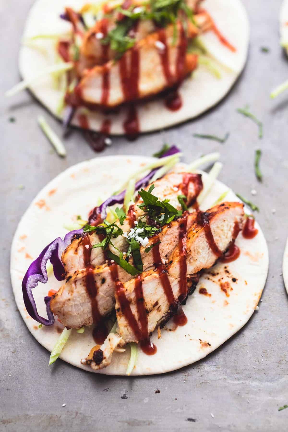 a mini grilled bbq chicken taco with another taco in the background.