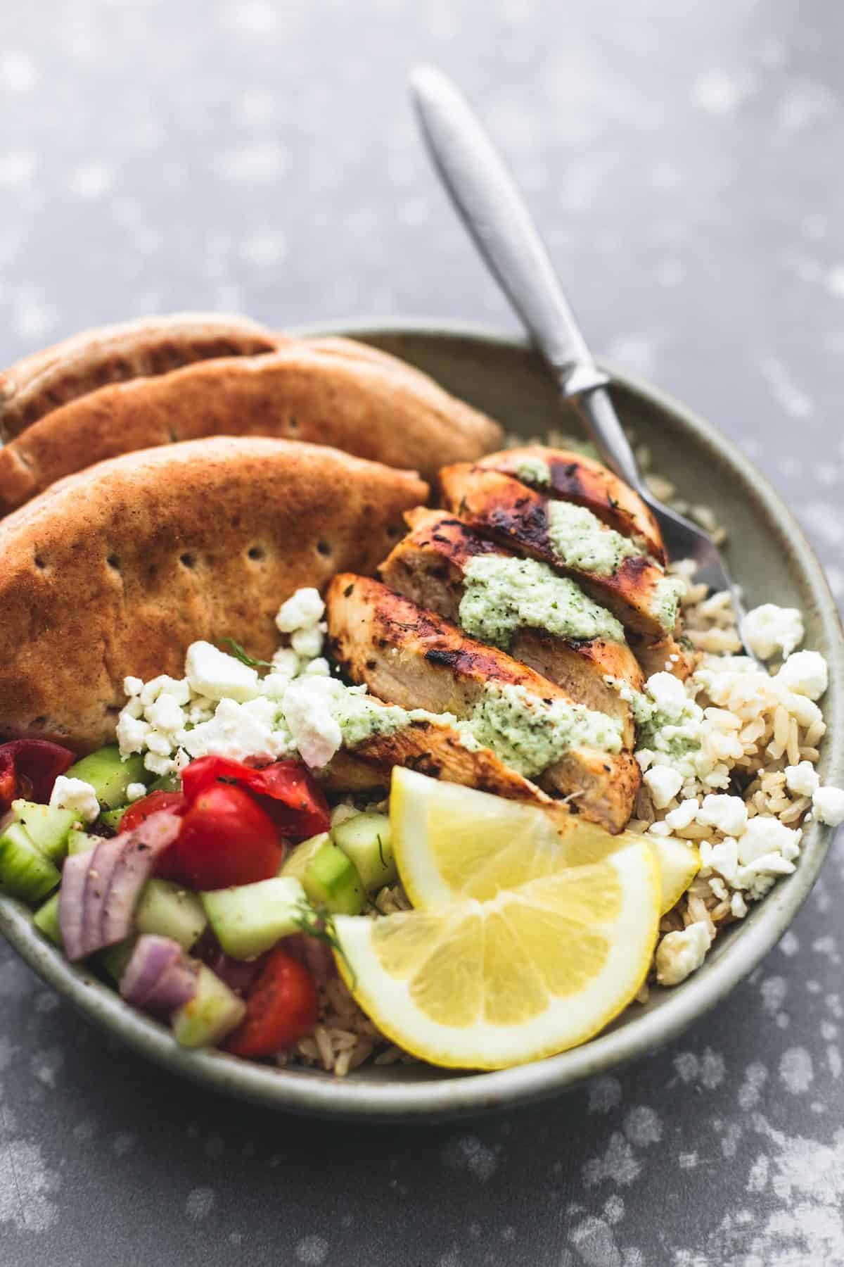 a meal prep Greek chicken gyro bowl with a fork.