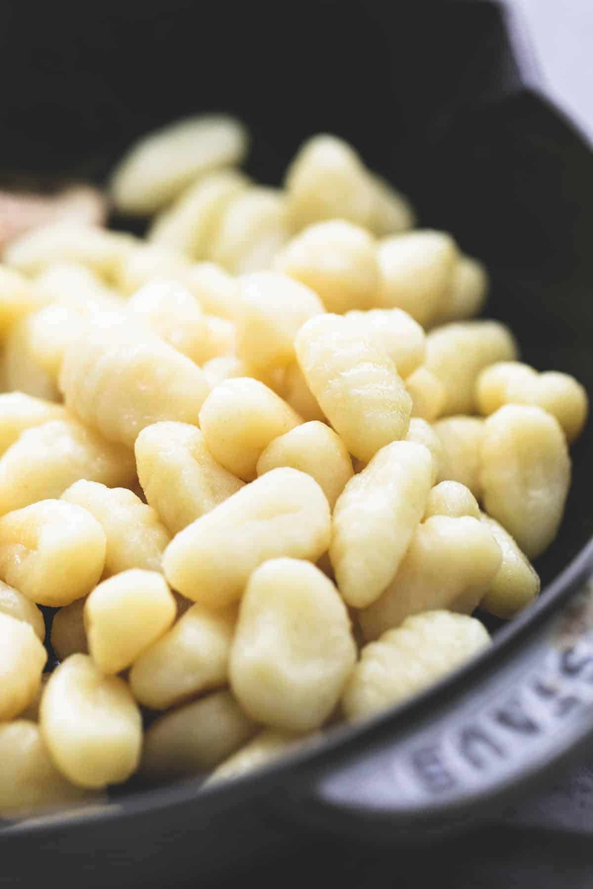close up of uncooked gnocchi in a skillet.