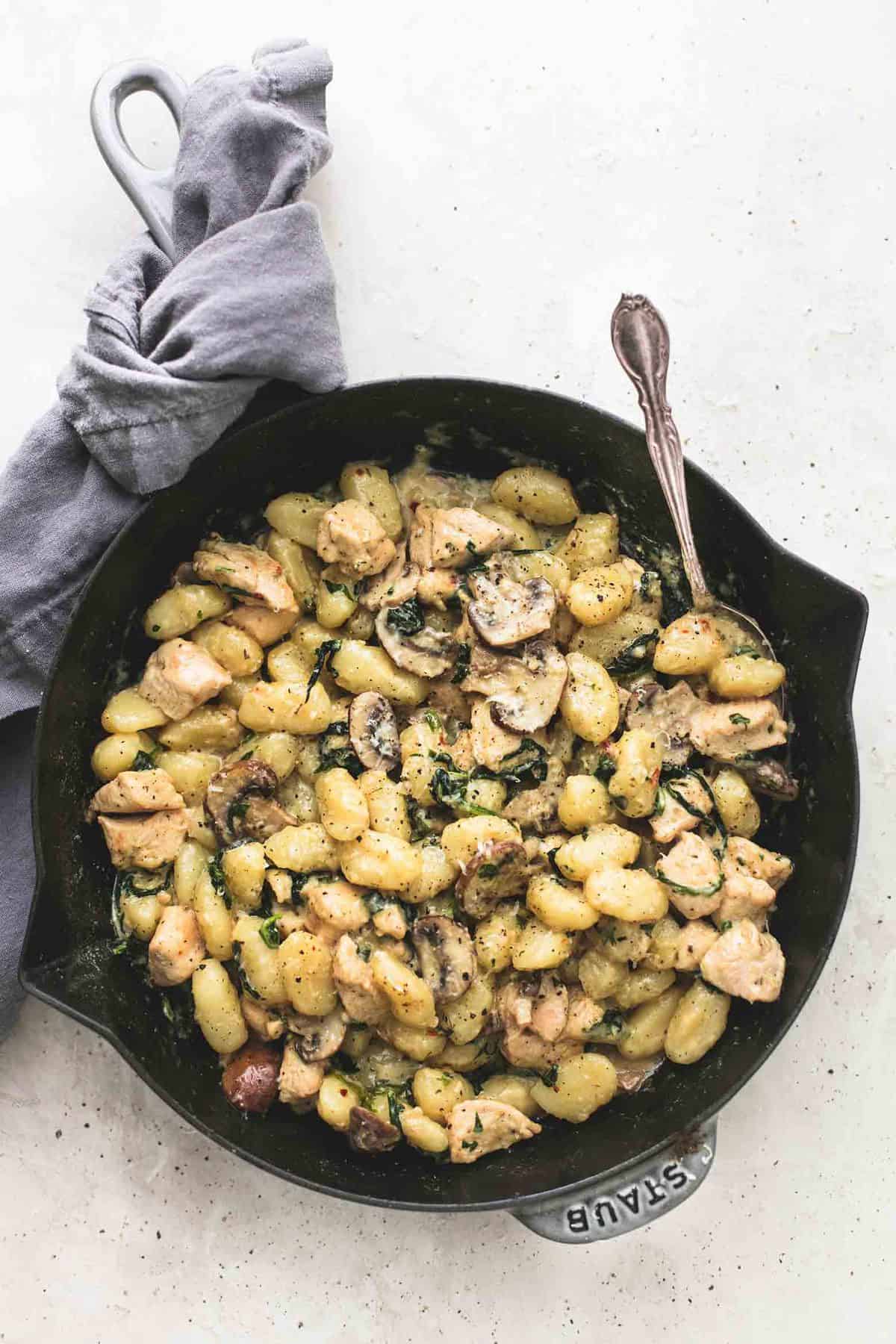 top view of chicken and mushroom gnocchi skillet with a spoon in a skillet.