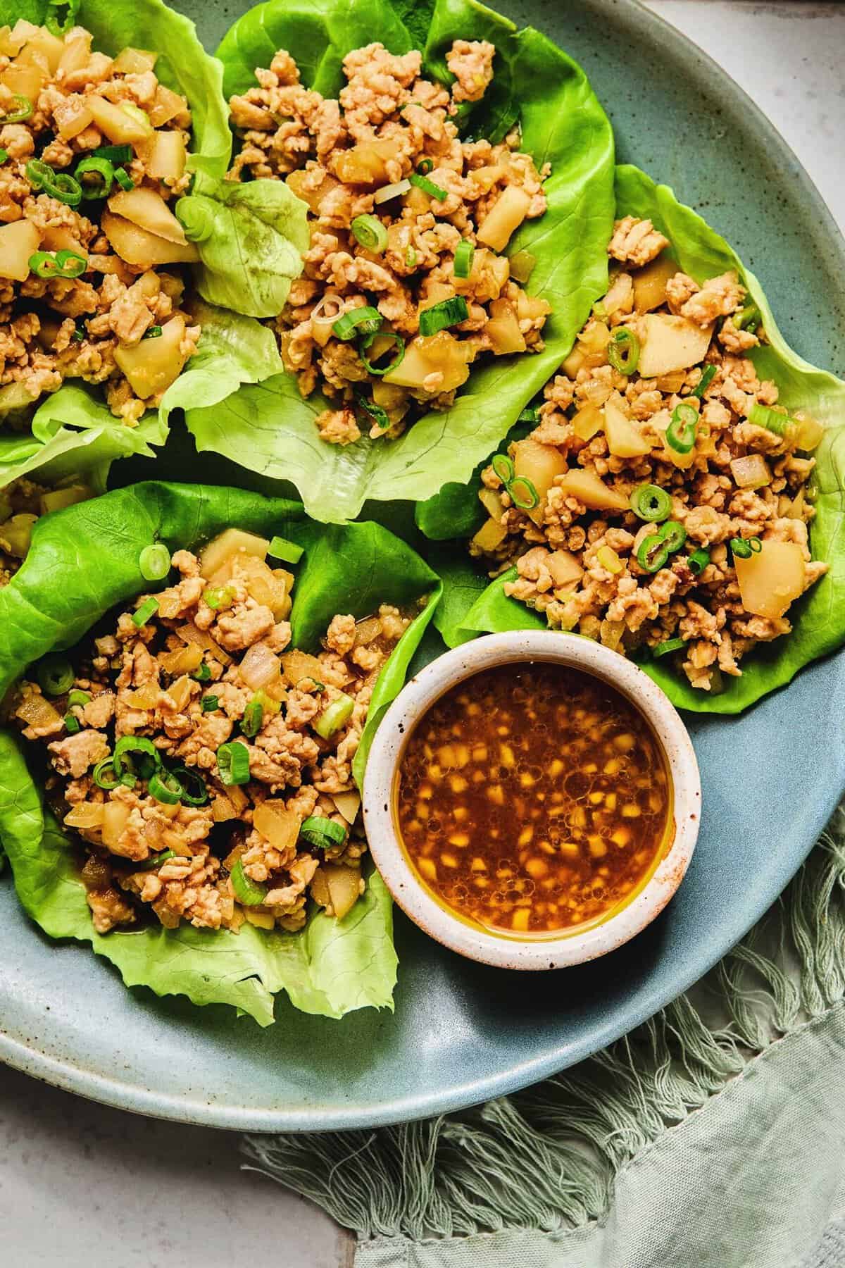 Close up of Asian chicken lettuce wraps on a plate.