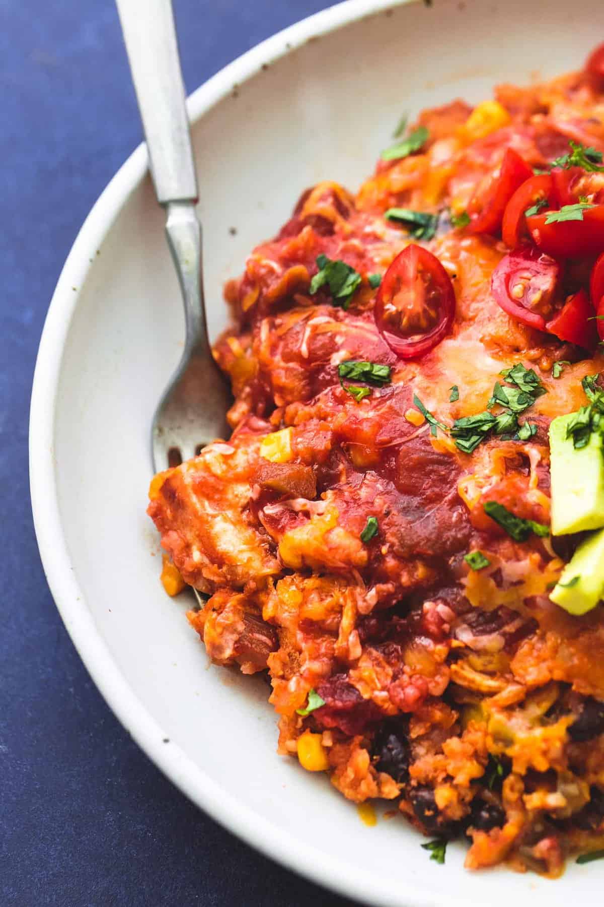 close up top view of instant pot cheesy Mexican chicken and rice with a fork in a bowl.