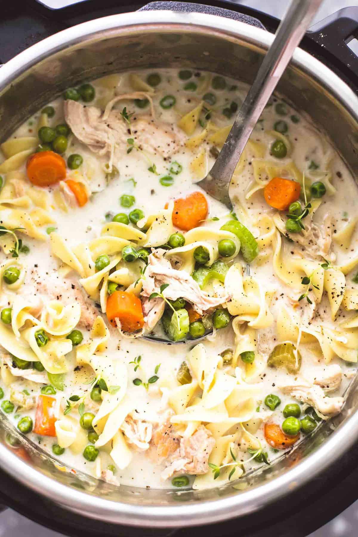 Slow Cooker OR Instant Pot Creamy Chicken Noodle Soup | lecremedelacrumb.comtop view of creamy chicken noodle soup with a serving spoon in an instant pot.