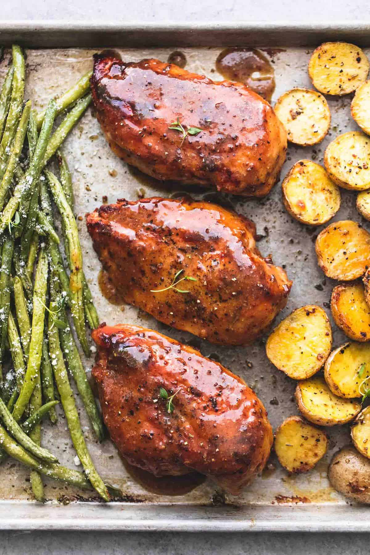 close up top view of sheet pan chicken potatoes and green beans on a sheet pan.