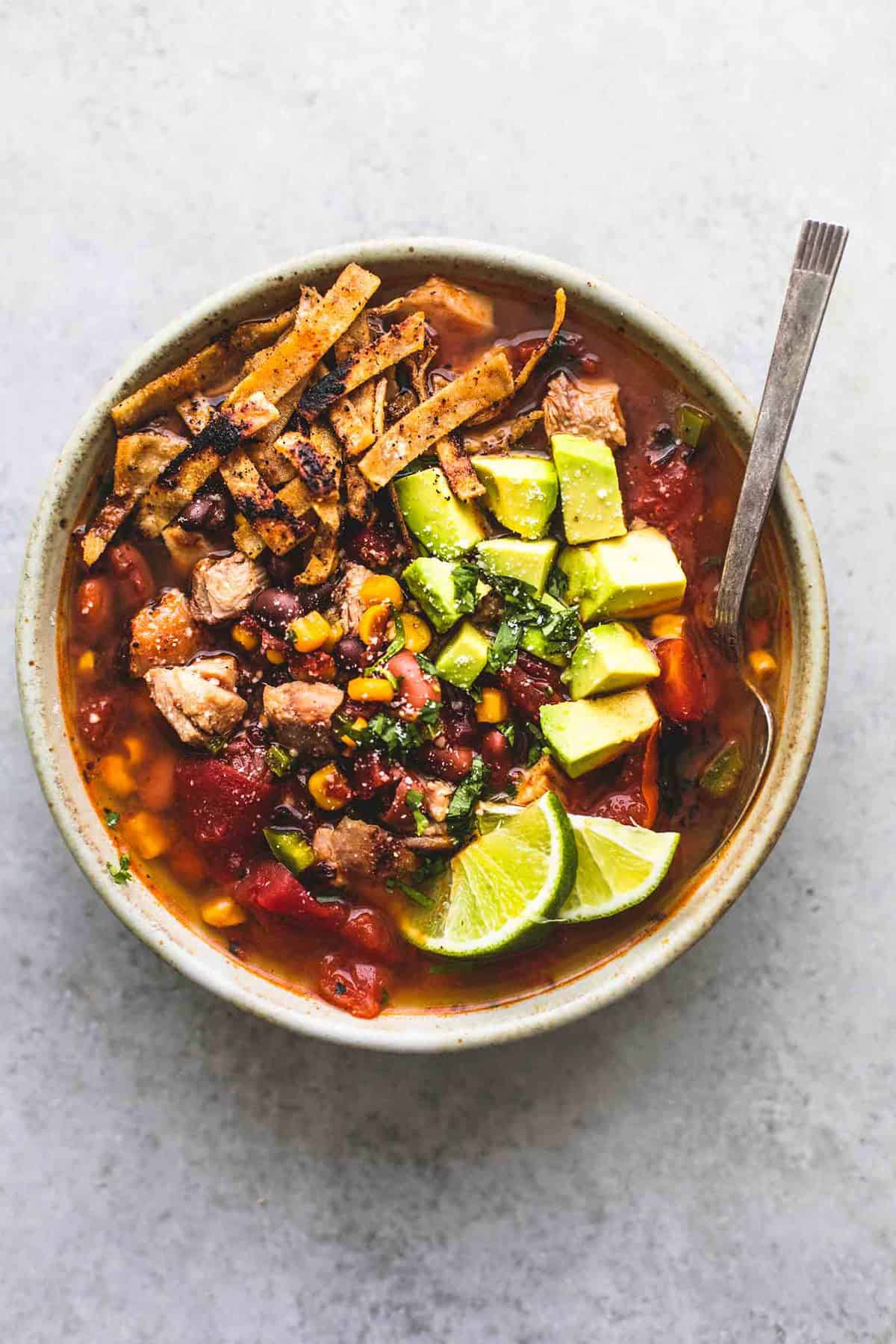 top view of Mexican chicken tortilla soup with a spoon in a bowl.