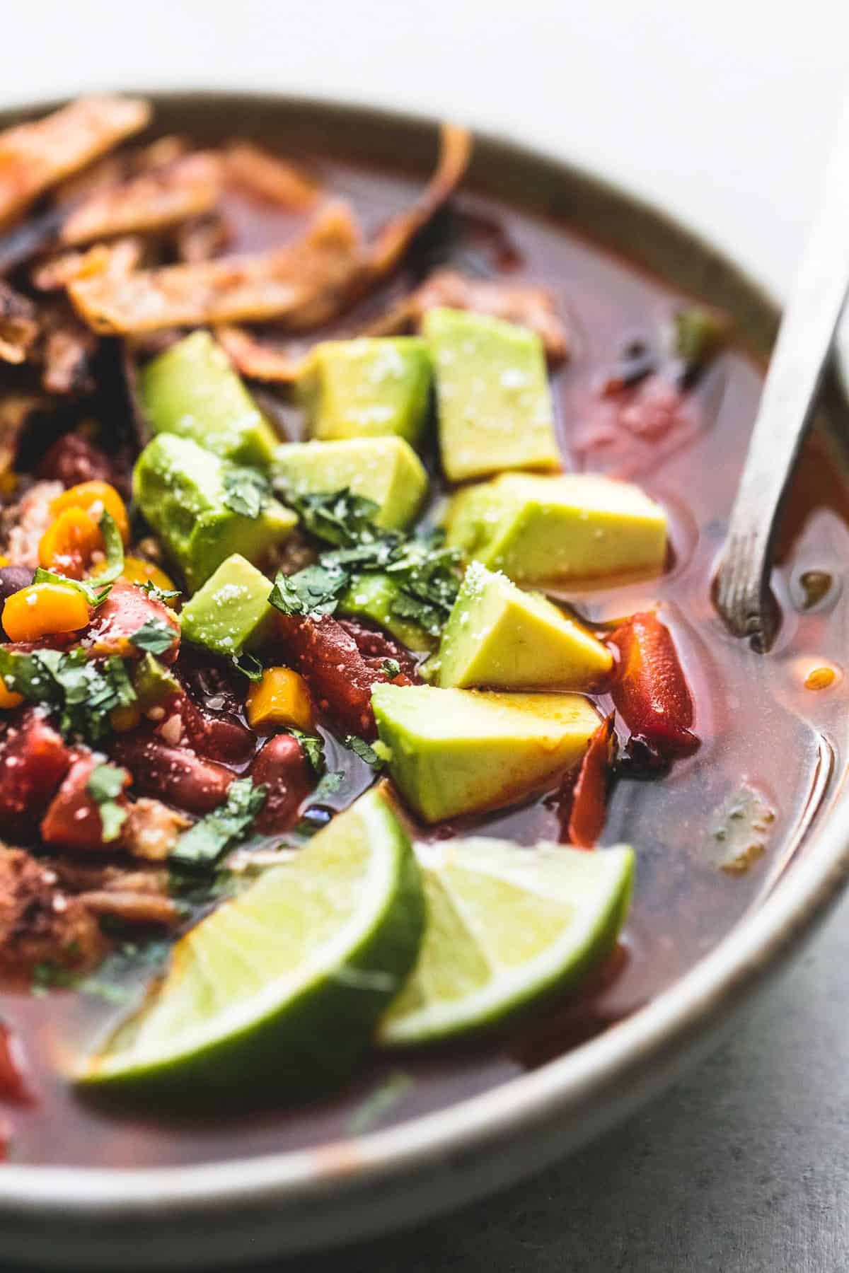 close up of Mexican chicken tortilla soup with a spoon in a bowl.