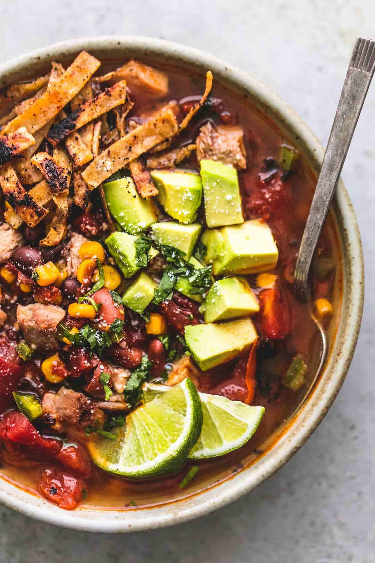 close up top view of Mexican chicken tortilla soup with a spoon in a bowl.