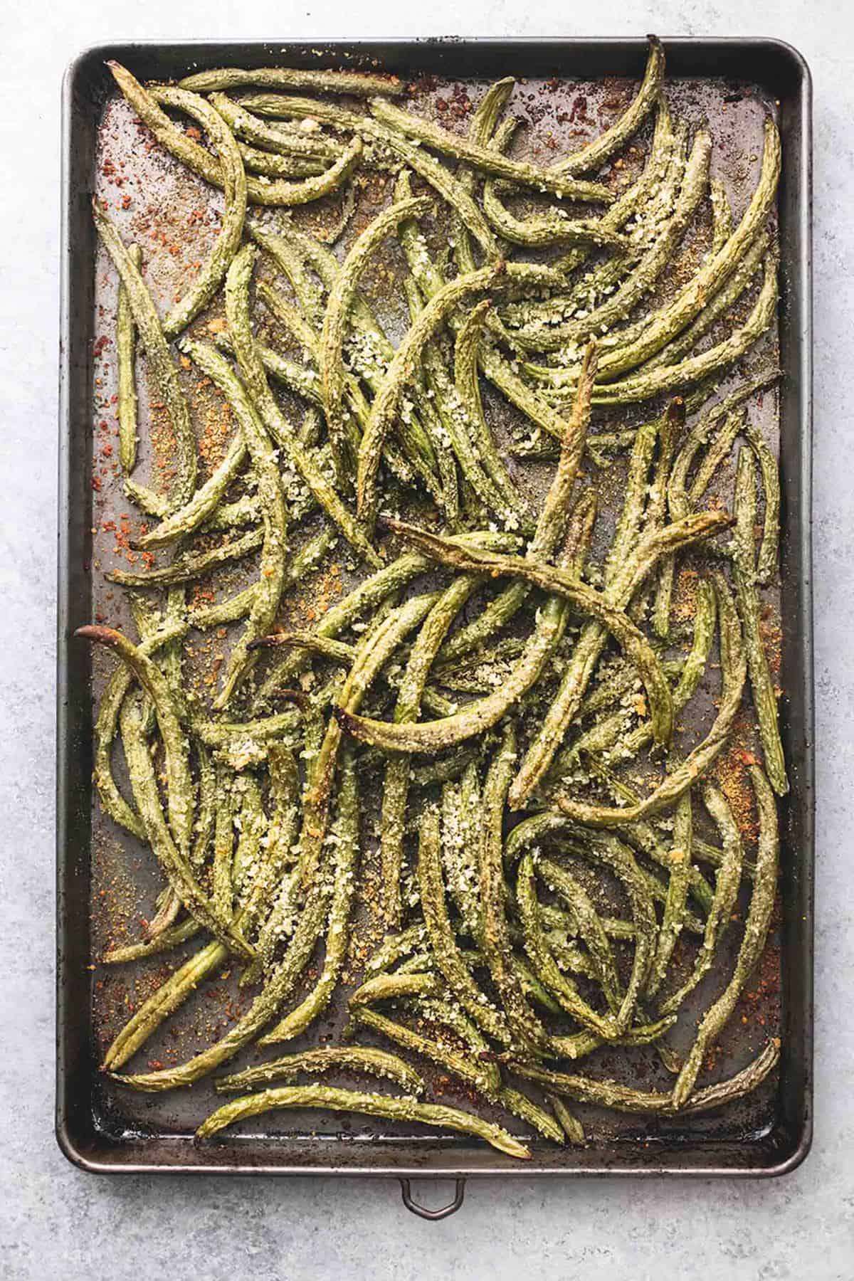 top view of crispy parmesan green beans on a baking sheet.