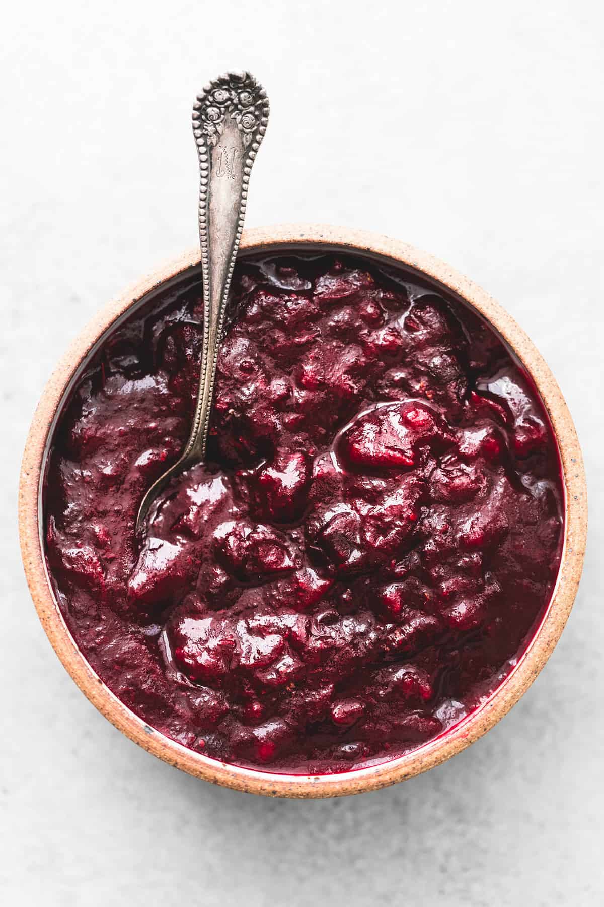 top view of cranberry sauce with a spoon in a bowl.