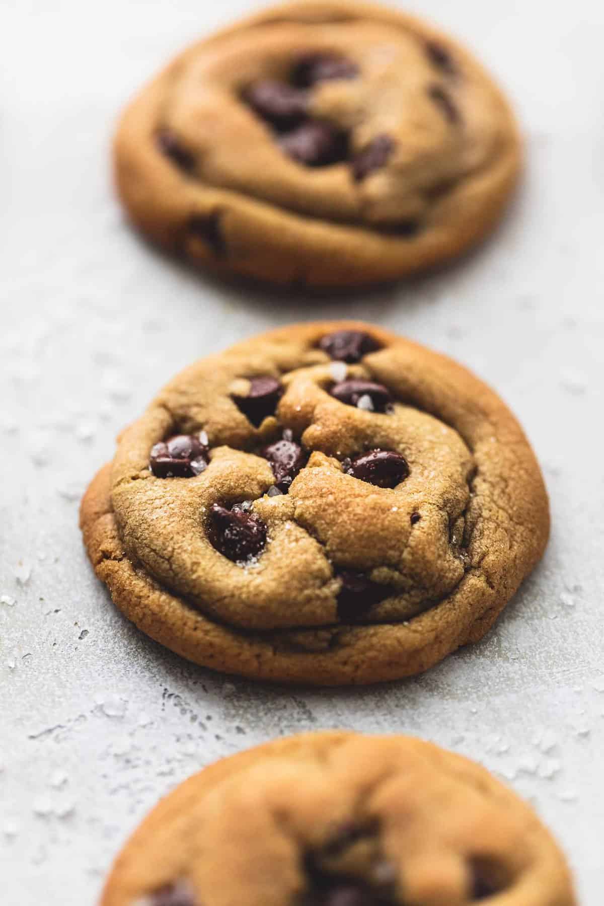 cookie butter chocolate chip cookies in a vertical row with the middle cookie being in focus.