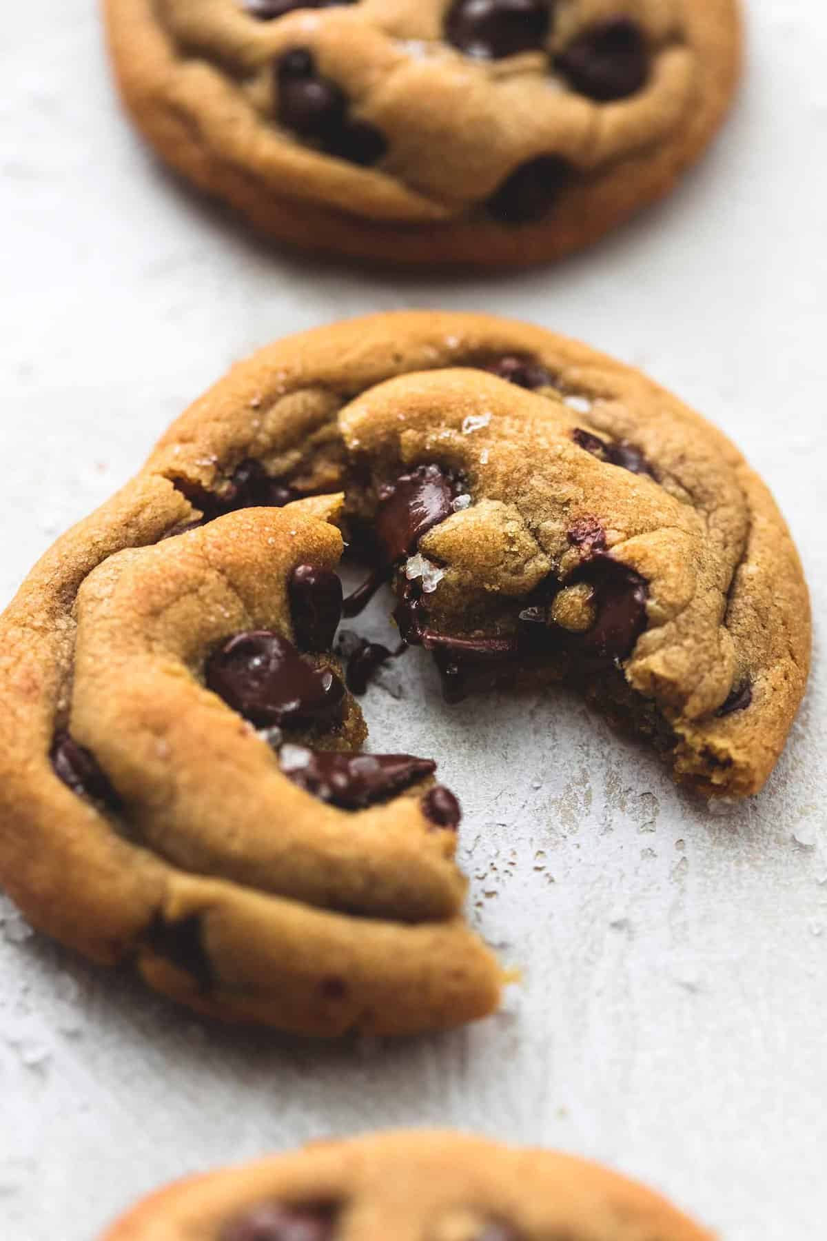 a cookie butter chocolate chip cookies broken in half with a cookie above and beneath it.