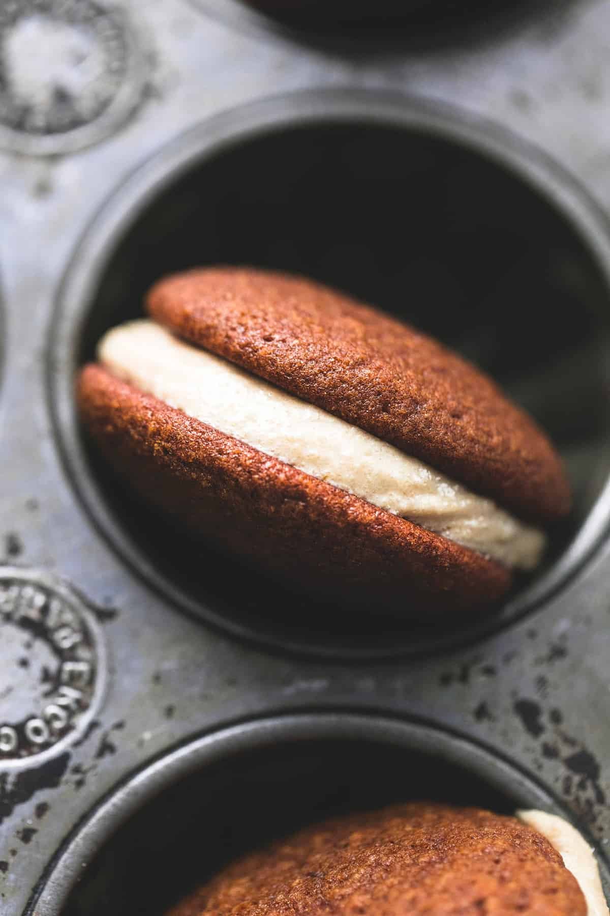 close up top view of a gingerbread whoopie pie in a muffin tin.