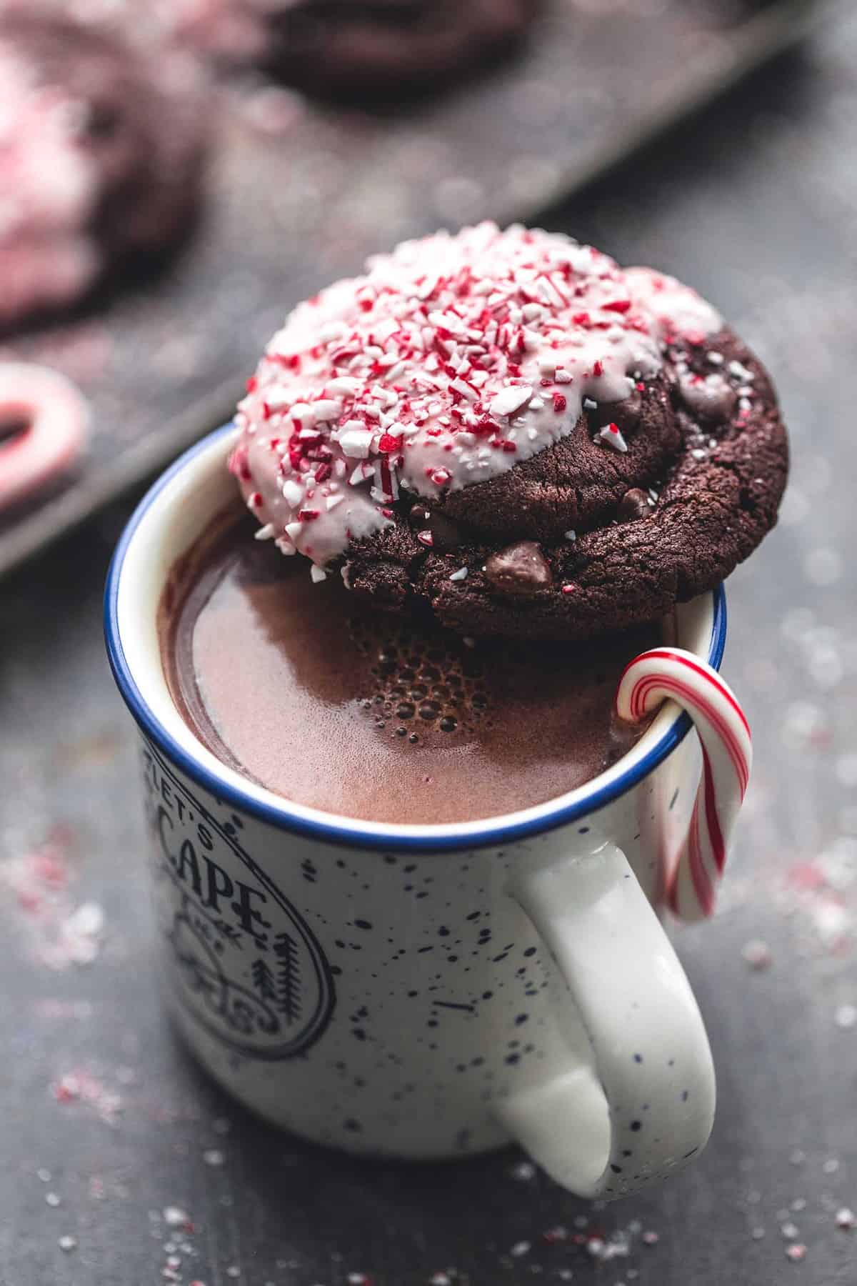 a double chocolate peppermint bark cookie sitting on top of a mug of hot chocolate.