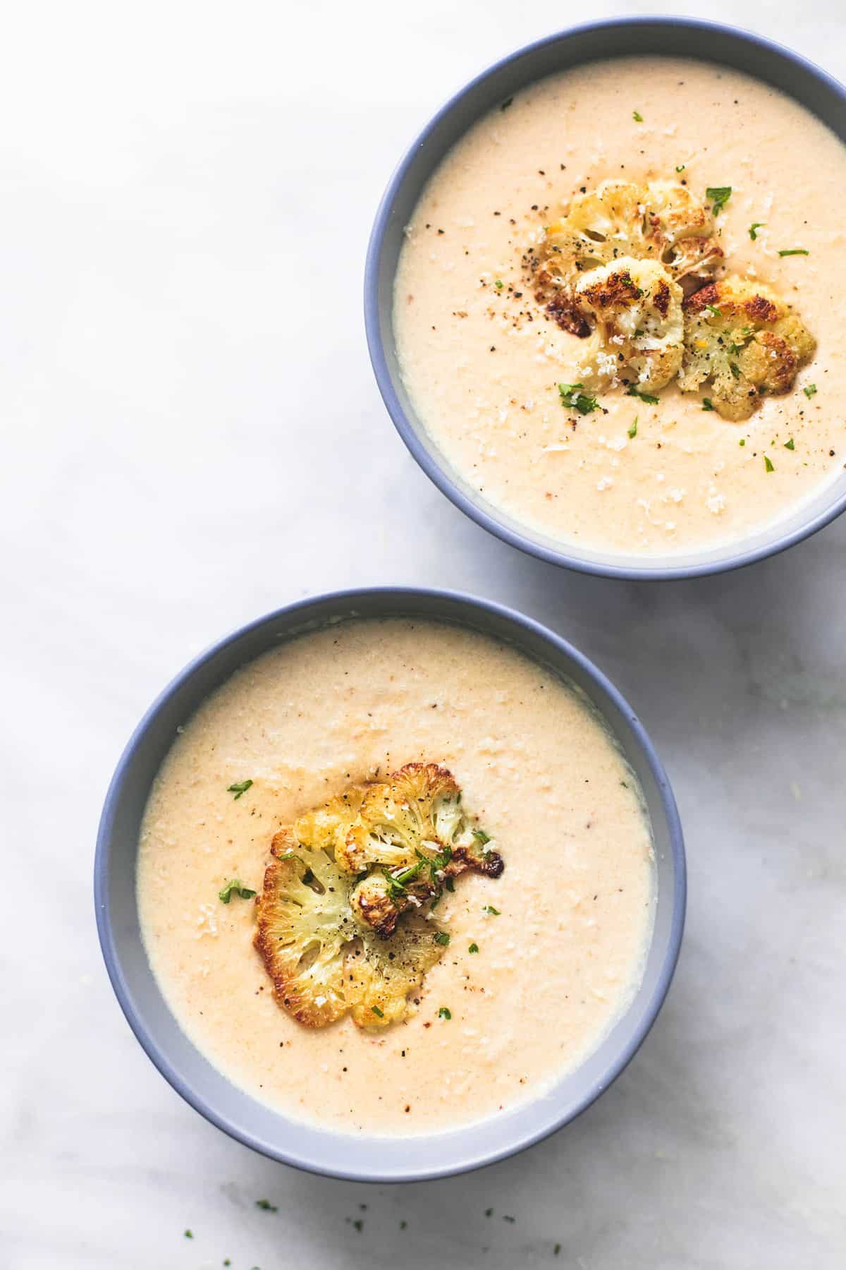 top view of two bowls of roasted cauliflower soup.