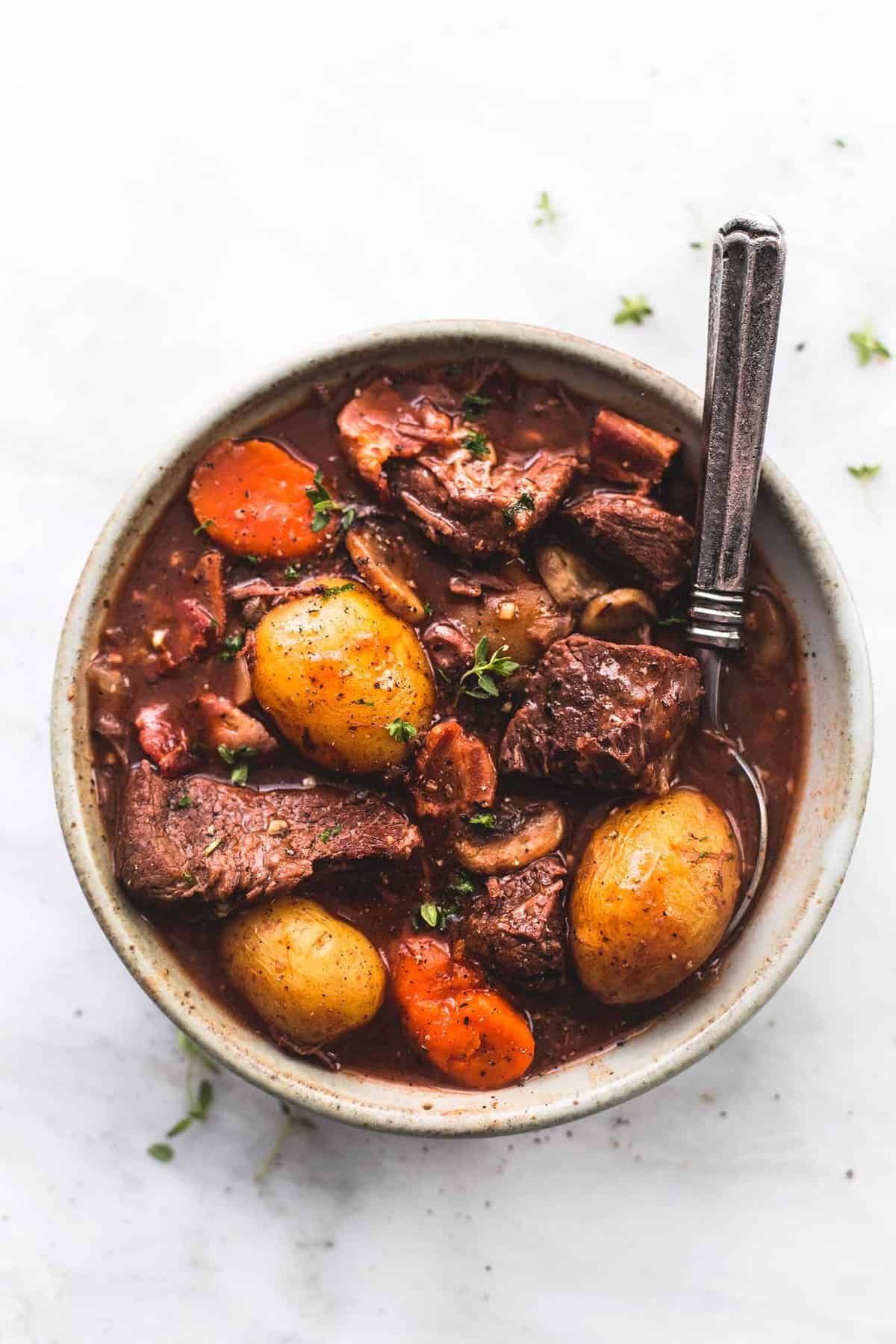 top view of instant pot beef bourguignon with a spoon in a bowl.